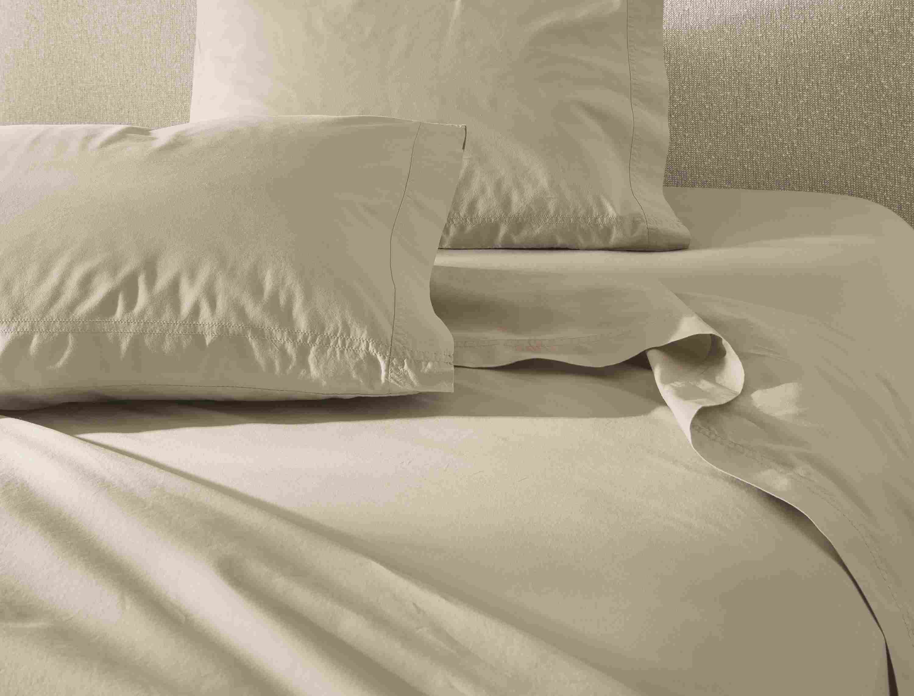 Detail of soft-washed queen sheet set in stone on a Luna queen bed in Conley Natural.