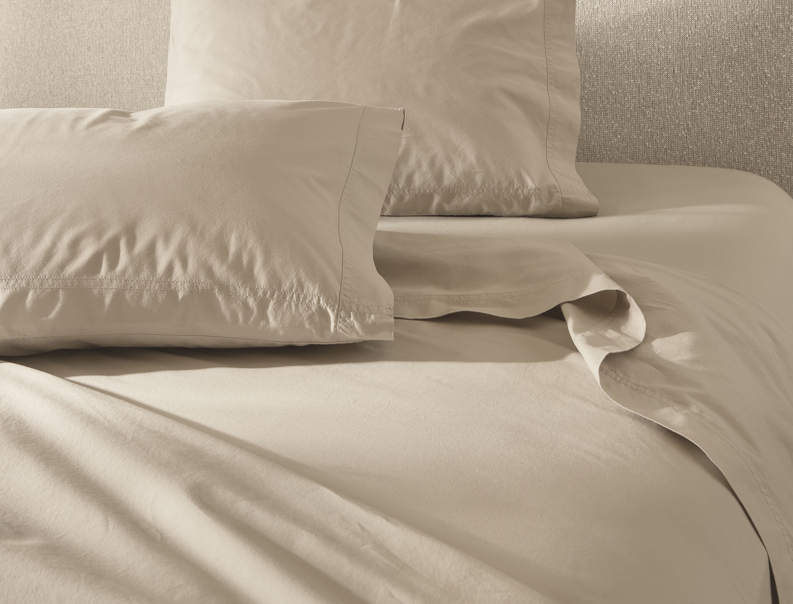 Detail of soft-washed queen sheet set in stone on a Luna queen bed in Conley Natural.