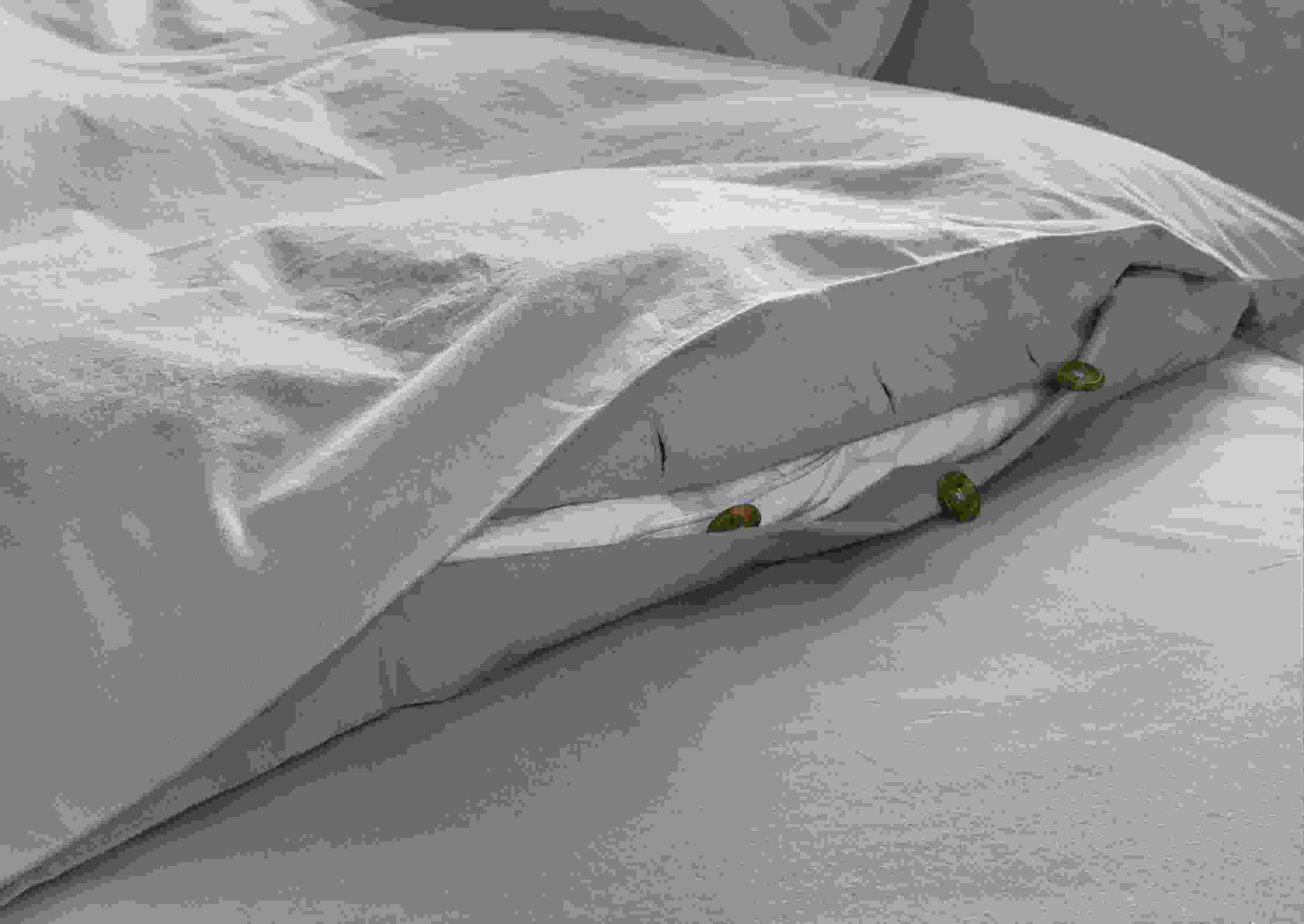 Detail of button closure on soft-washed percale full/queen duvet set in lake colorway.