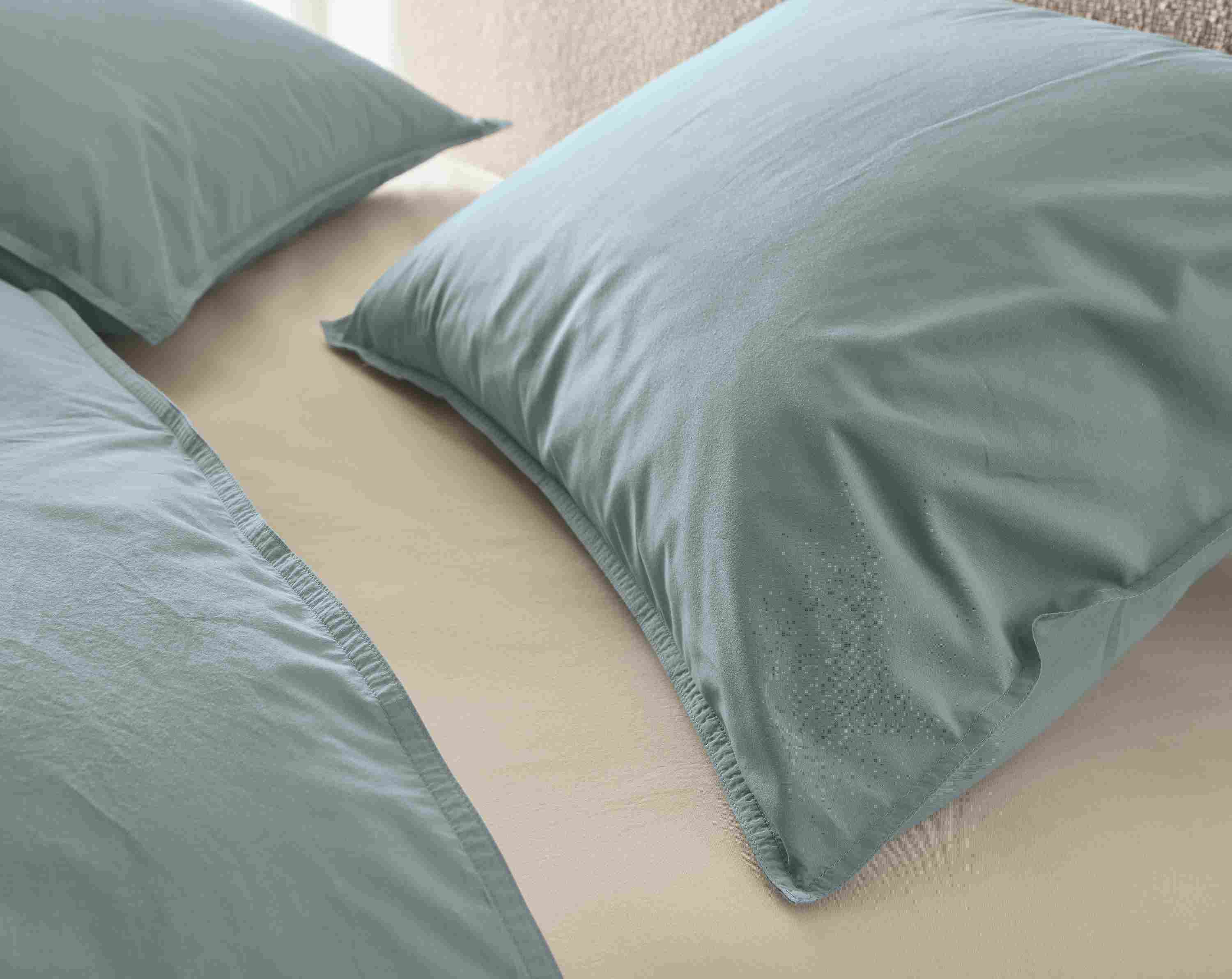 Detail of Soft-washed sheet and duvet set in lake and stone on Luna bed in conley natural.