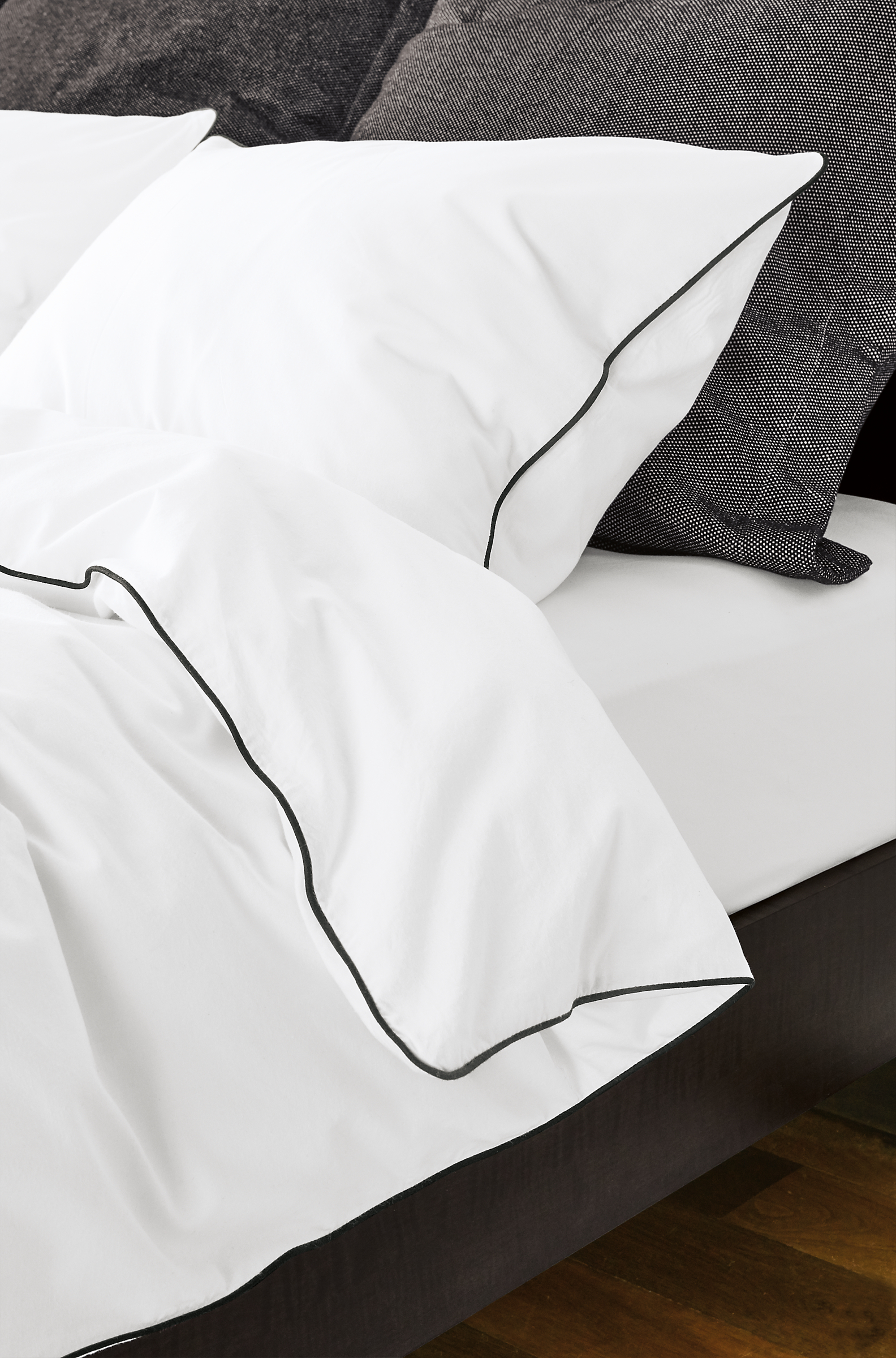 Detail of Sommerville bedding with black piping on bed.