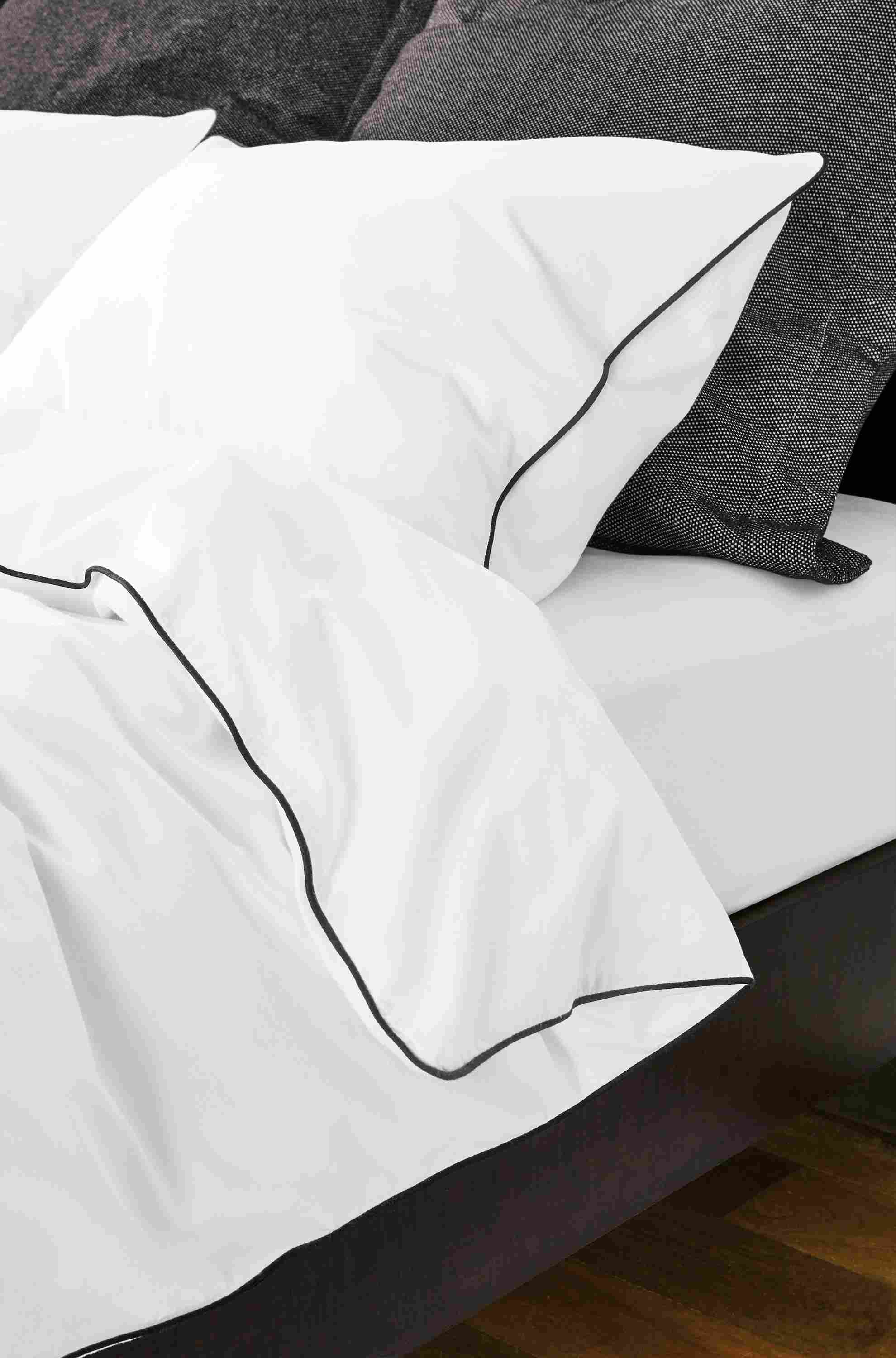 Detail of Sommerville bedding with black piping on bed.