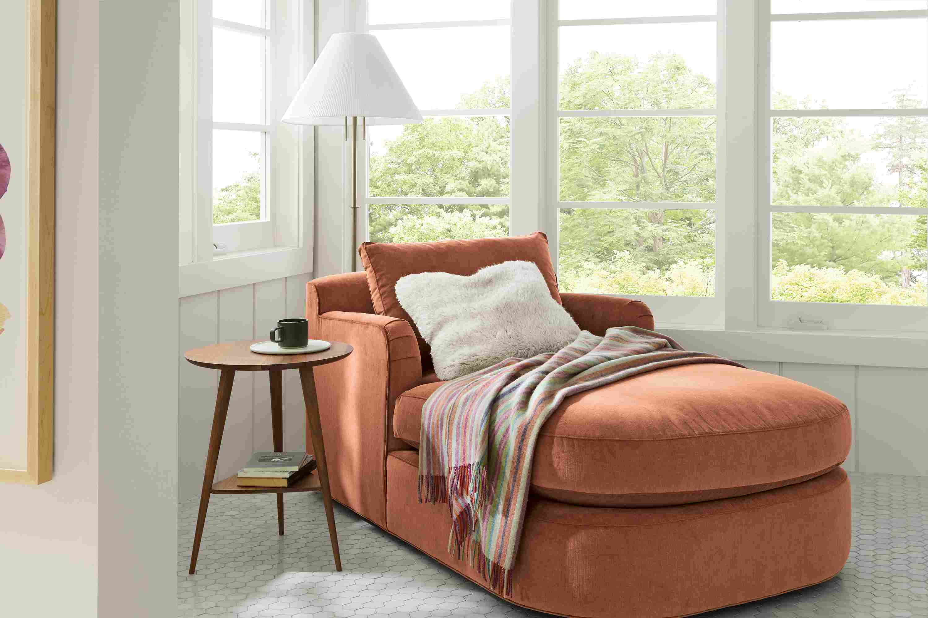Sunroom with Sonja chaise in Windsor Clay, Rae round end table in walnut and Clifton throw blanked in multicolor.