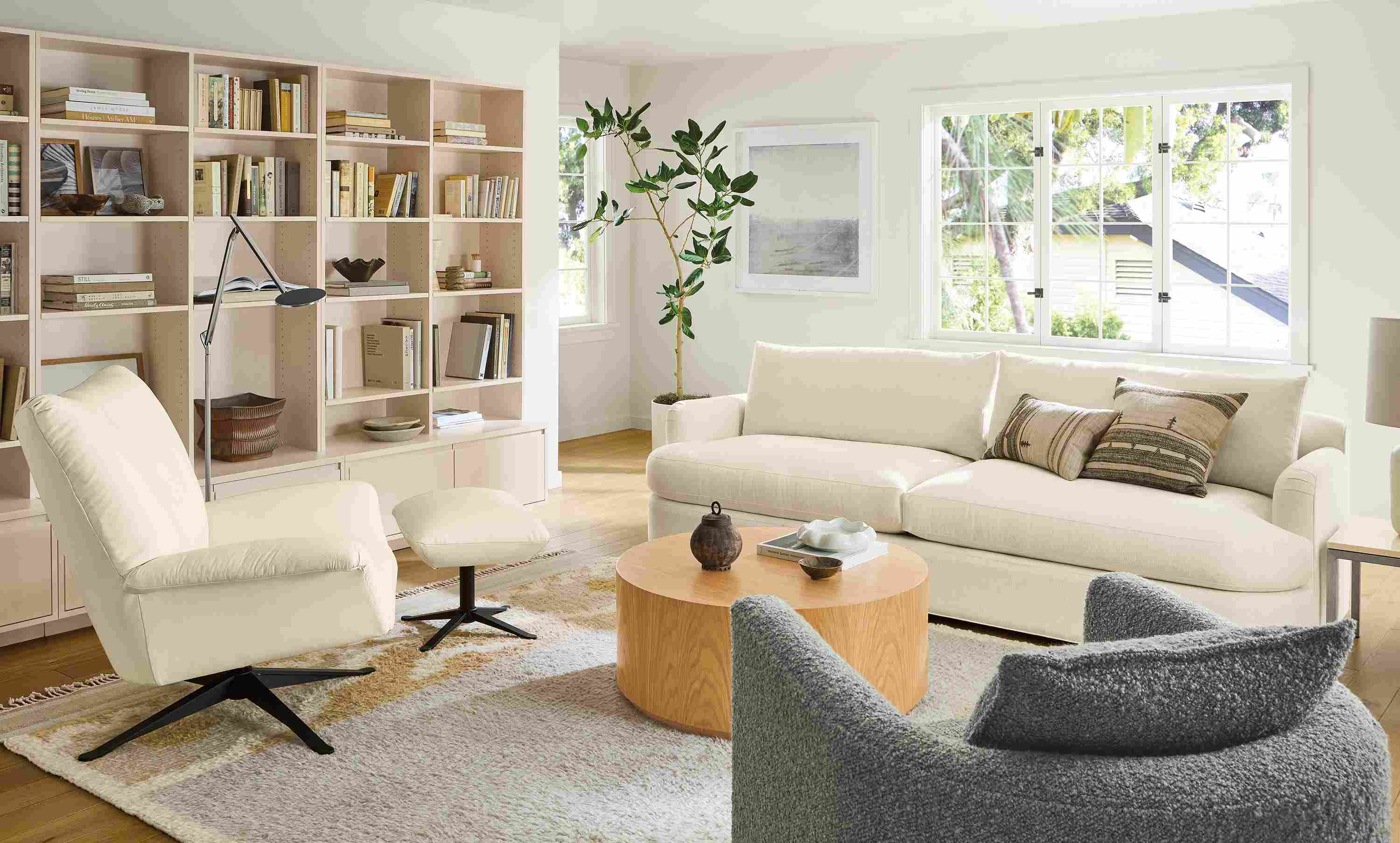 Living room with sonja sofa in hawkins ivory and paris swivel chair and ottoman in pesaro ivory with tova rug.