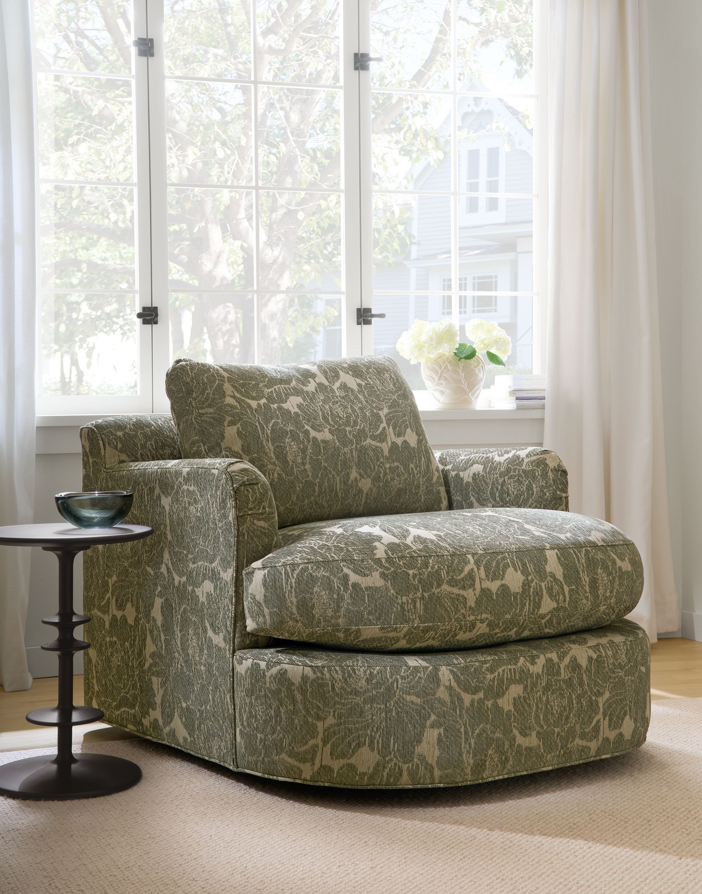 Living room with Sonja swivel chair in Caldwell Olive, Flannery rug in oatmeal and Park round end table in Charcoal.