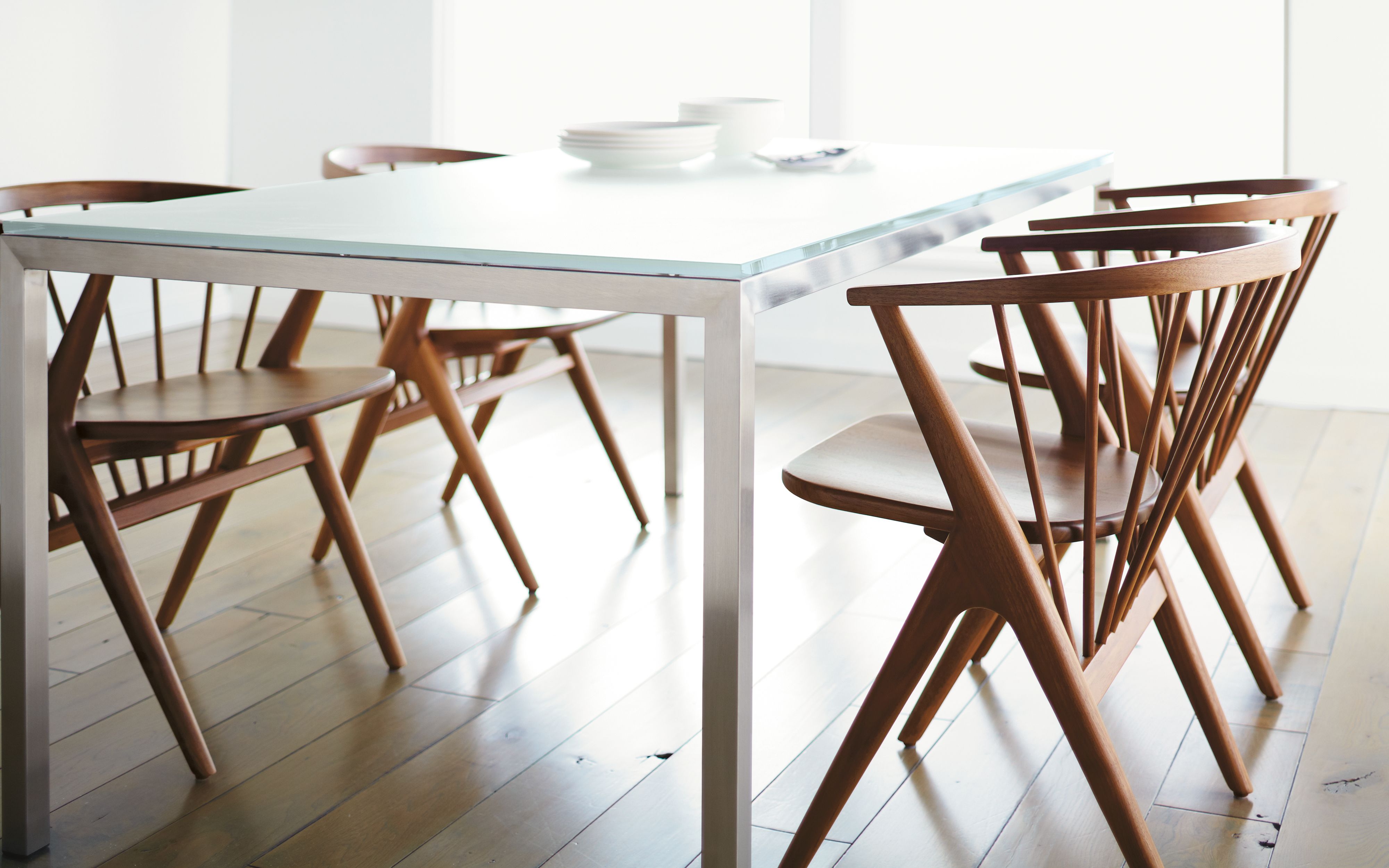 room setting with soren chairs in walnut and glass and steel table.