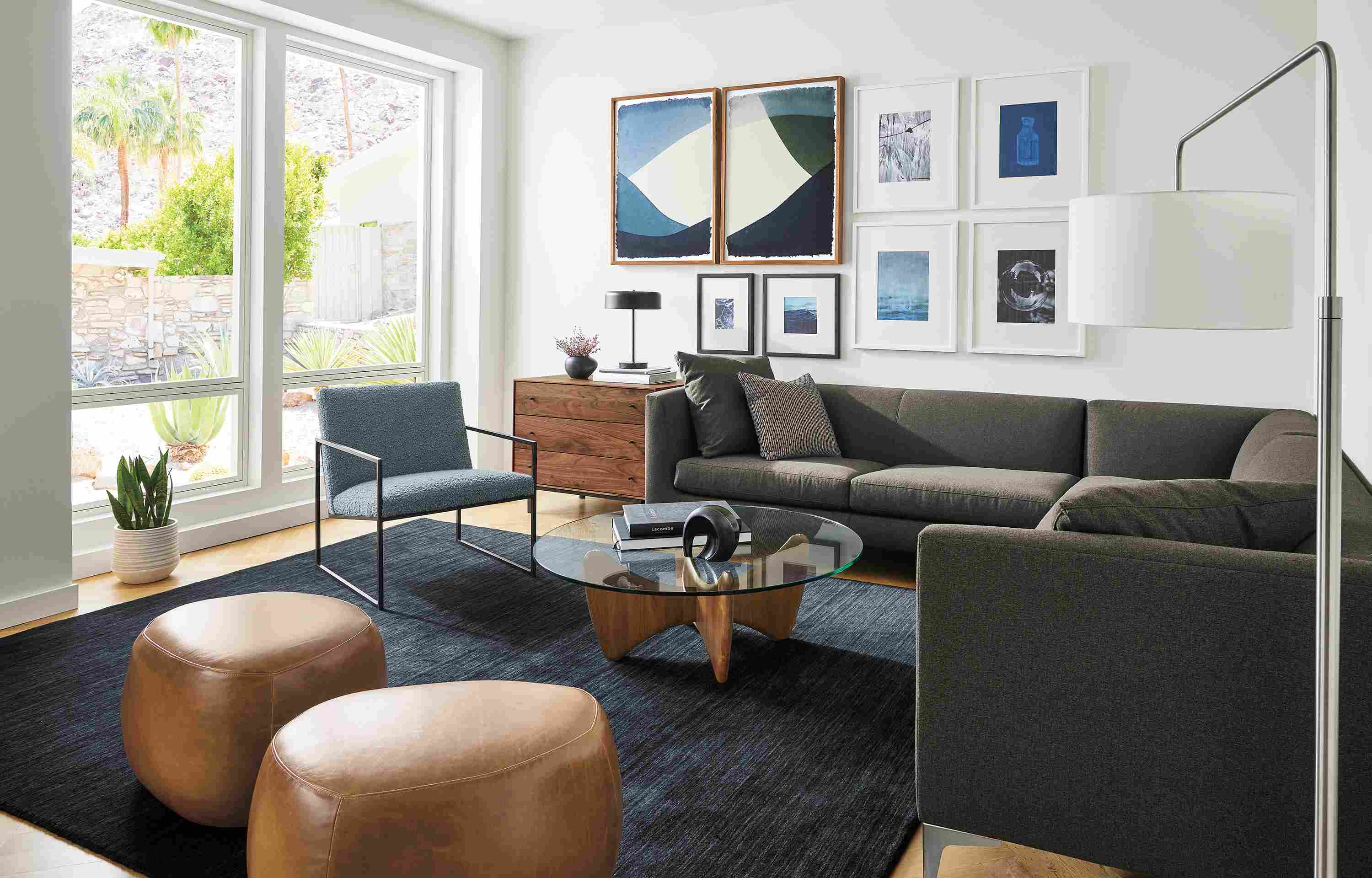 Living room with Sterling sectional in Myers Charcoal Novato chair in Dornick Haze two asher ottomans in vento cognac leather.