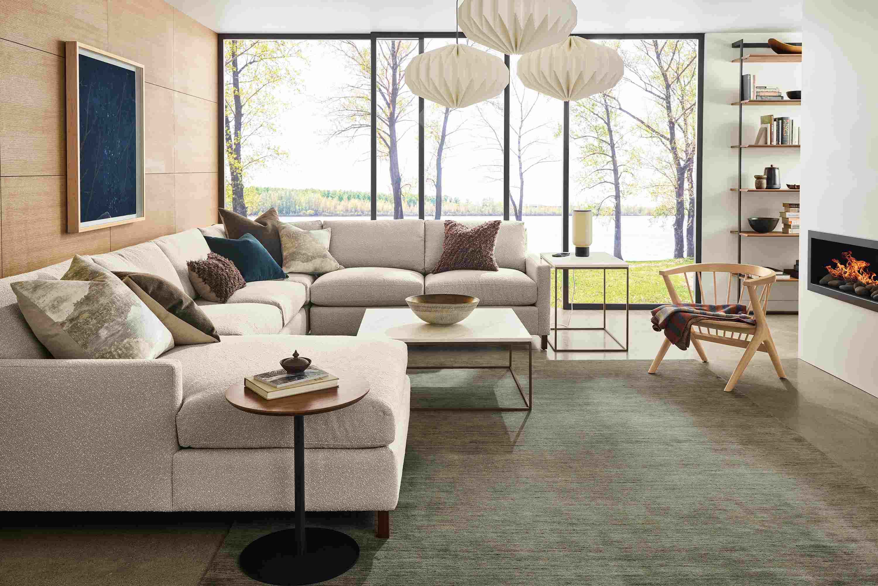 Living room with Stevens 149-wide sectional sofa in Declan Natural, Soren lounge chair in salt on red oak and Nomad rug in olive.