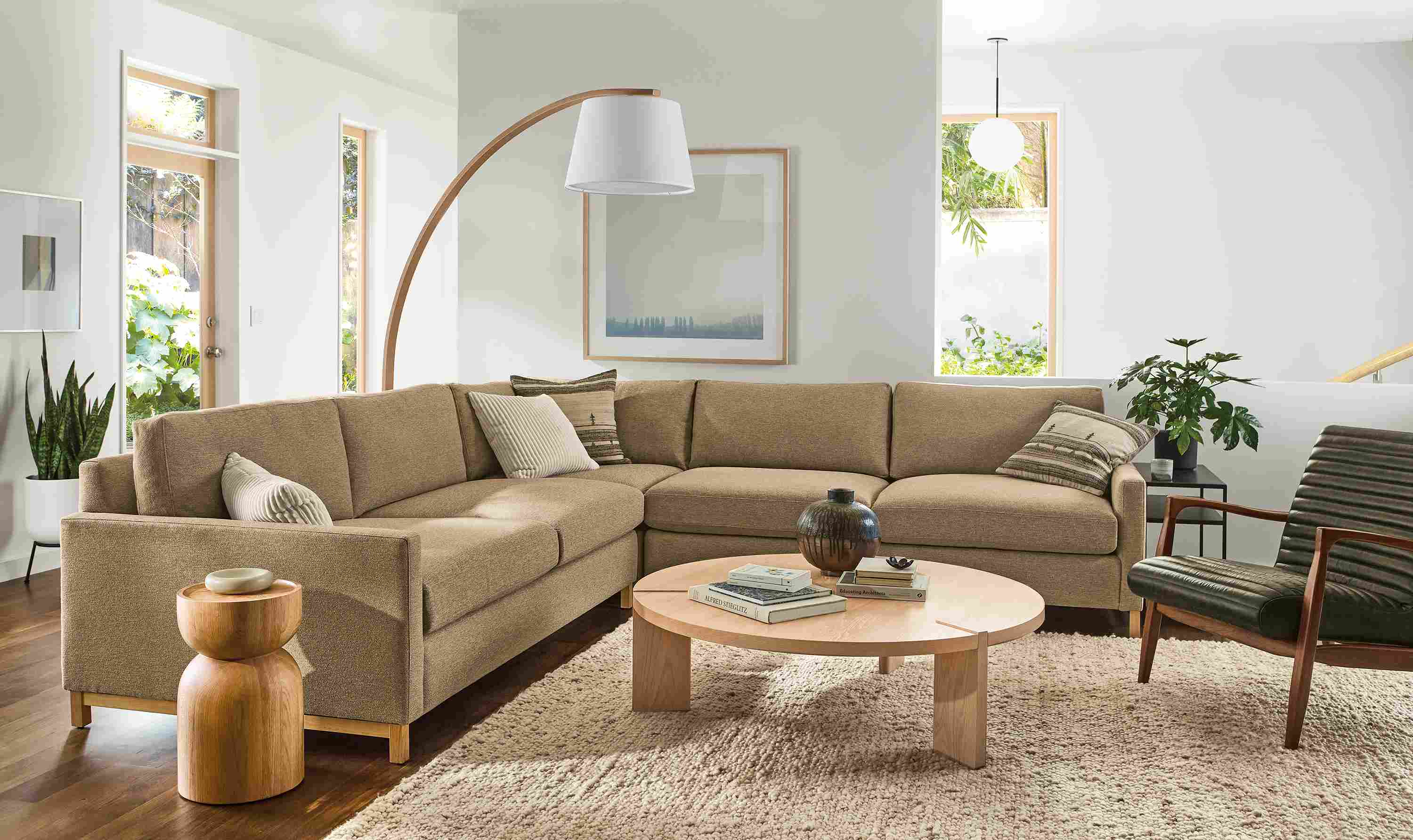 Living room with stevens 119 by 119 three-piece sectional sofa in tatum taupe, callan chair in palermo olive an cobble rug in ecru.
