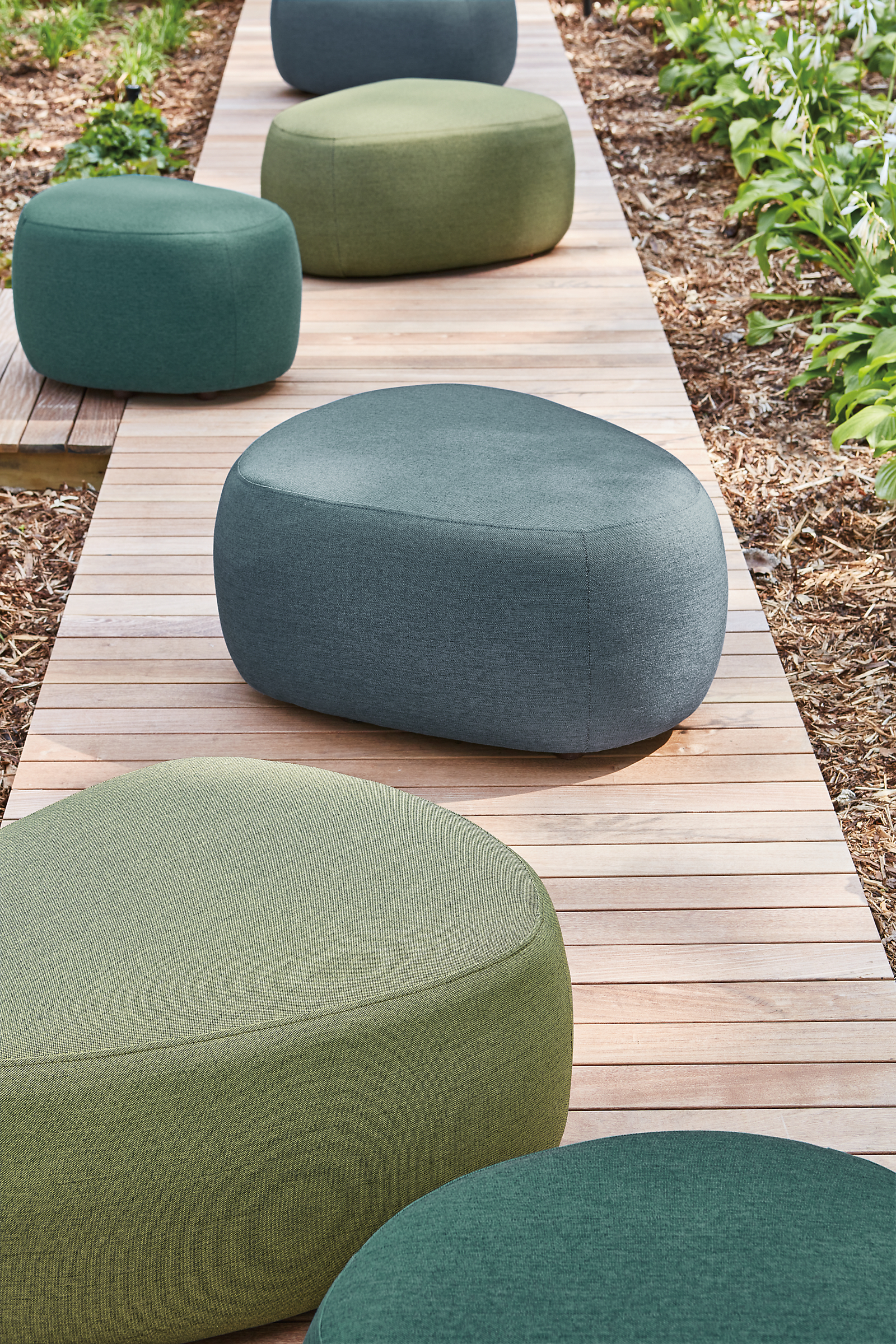 Outdoor boardwalk featuring 6 Stratford ottomans in green and blue.