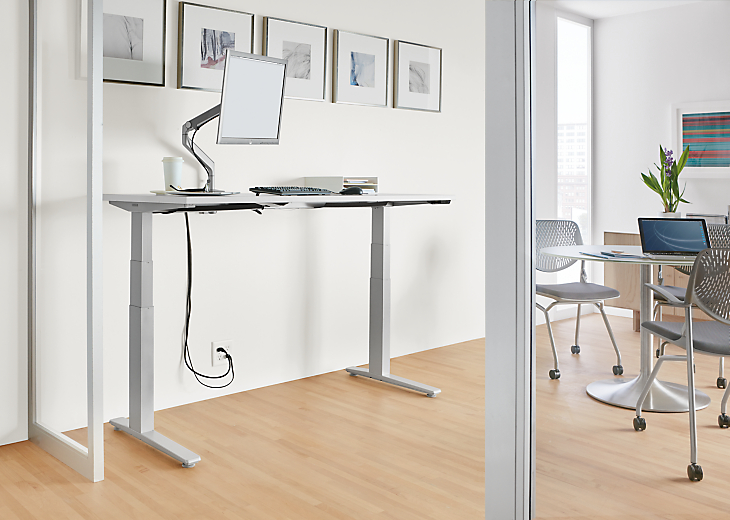 Office setting with SW 60-wide standing desk in the up position along with aria table and runa chairs.