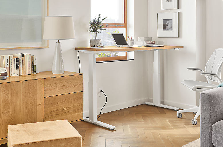 Home office setting with SW 60-wide standing desk in standing position and Diffrient World Office Chair in White.
