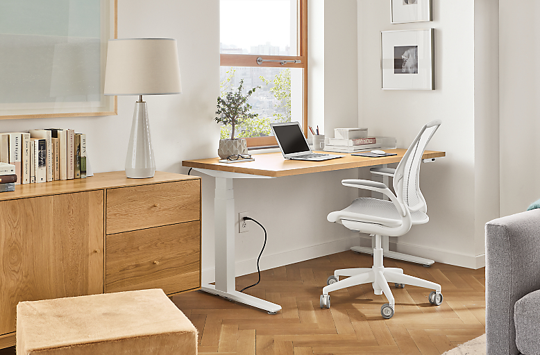 Home office setting with SW 60-wide standing desk in seated position and Diffrient World Office Chair in White.