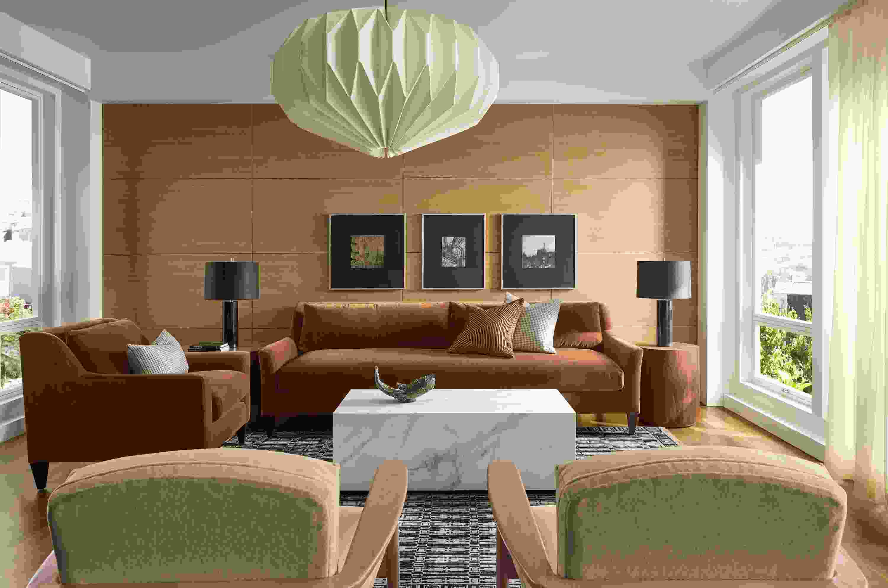 Sunny living room with Sybil sofa and chair in Redding Nutmeg, 2 Renew chairs in Terra Oatmeal and Tulum rug in Ebony.