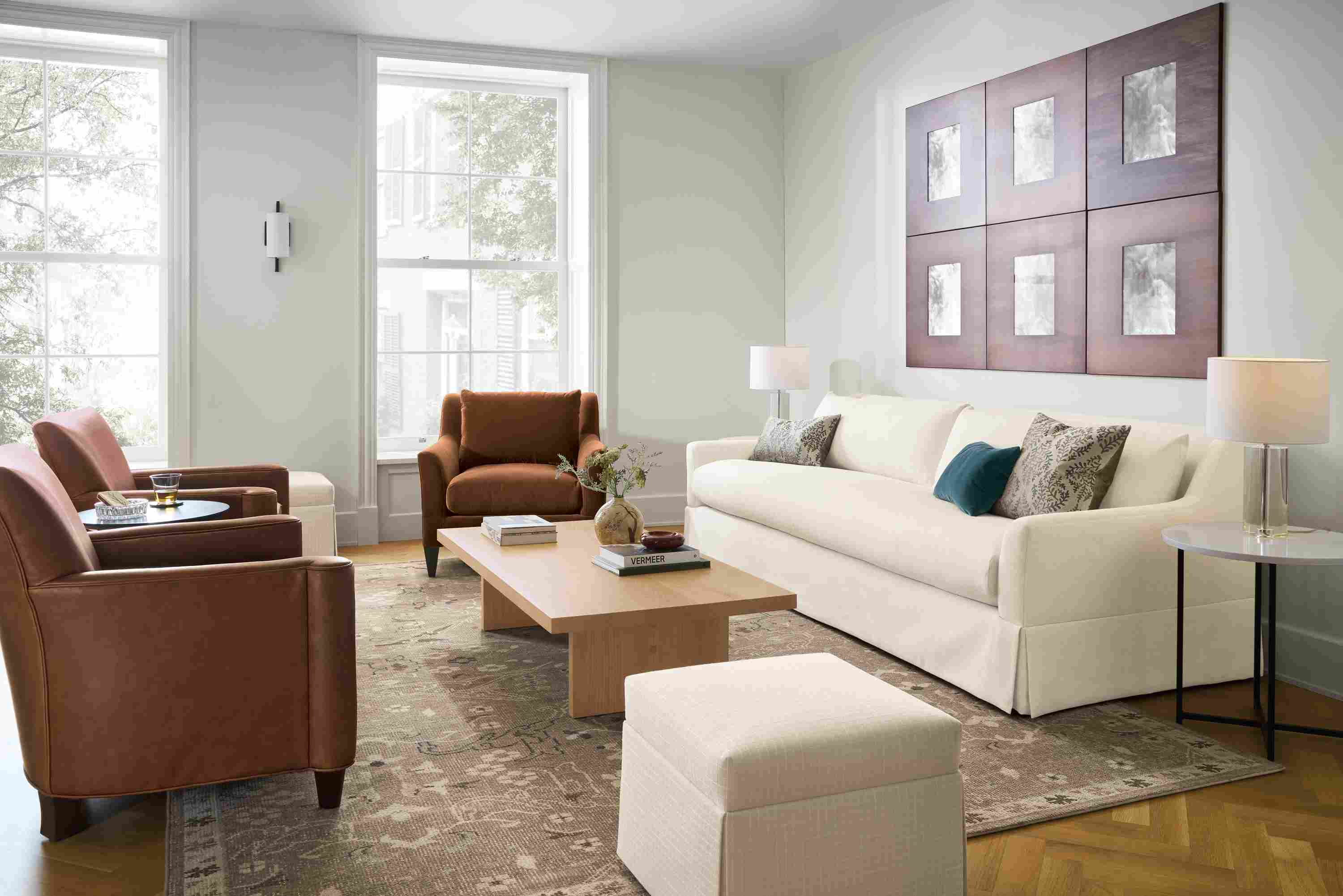 Living room with Sybil 100-wide skirted bench cushion sofa in Sumner Ivory and 2 Savoy chairs in Sarto Cognac leather.