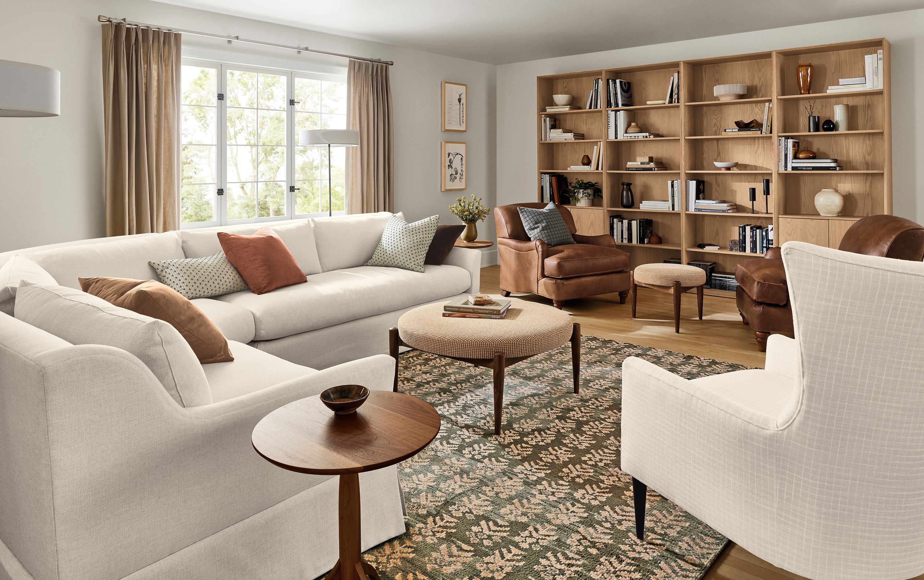 Large living room with Sybil 130 by 130 three-piece sectional in sumner ivory and 2 humphrey chairs in sarto cognac leather.