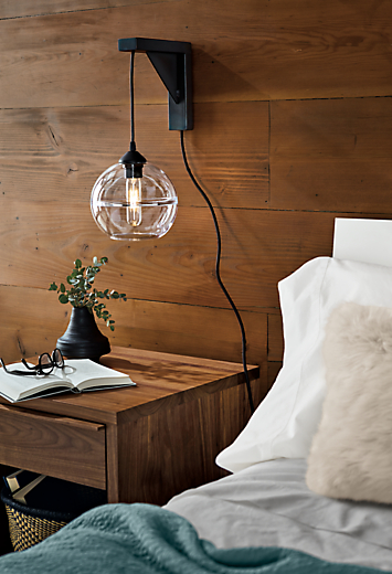 Detail of Tandem wall sconce in natural steel in bedroom.