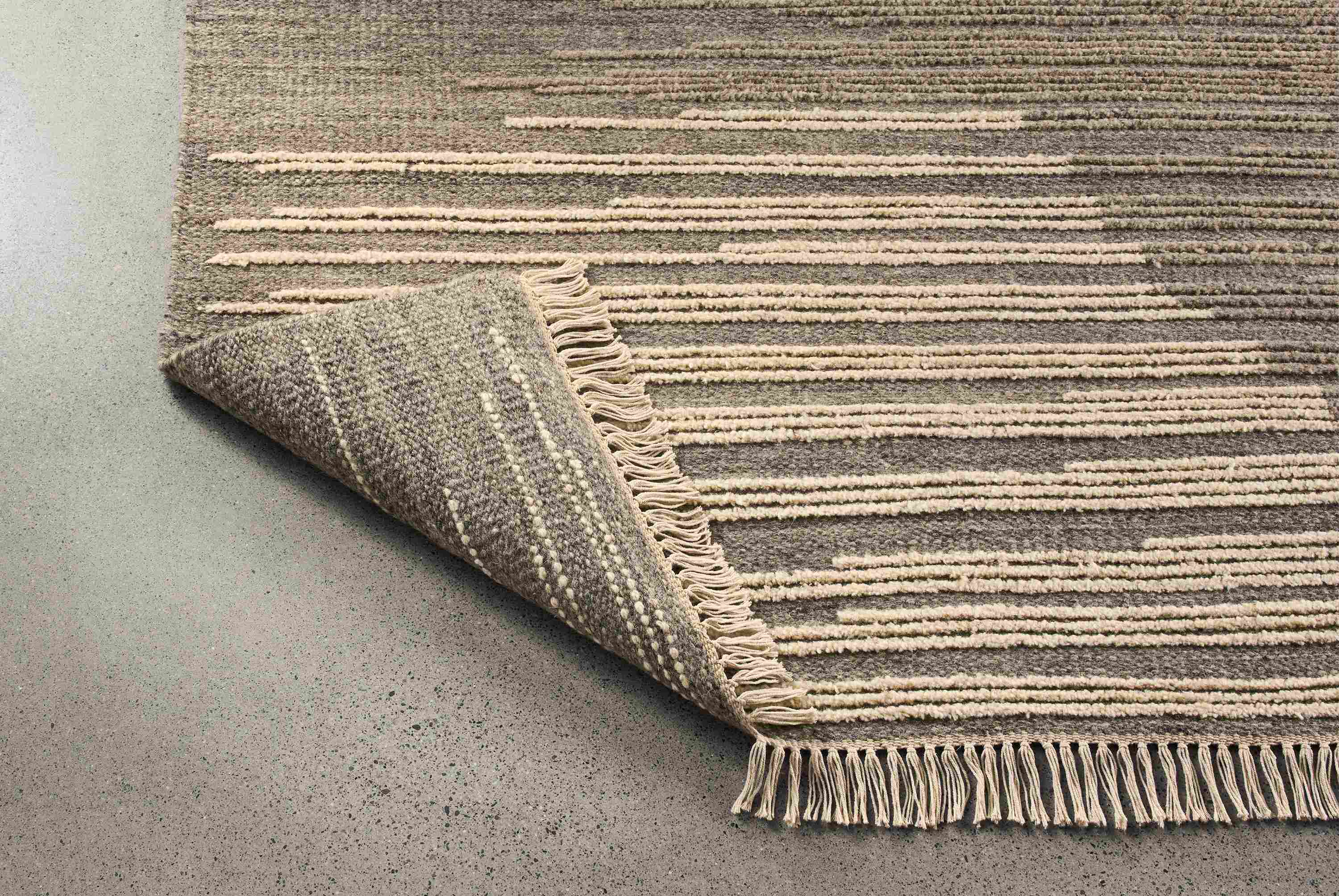 Tangier 8 by 10 rug in natural shown with corner flipped up to show underside of rug.