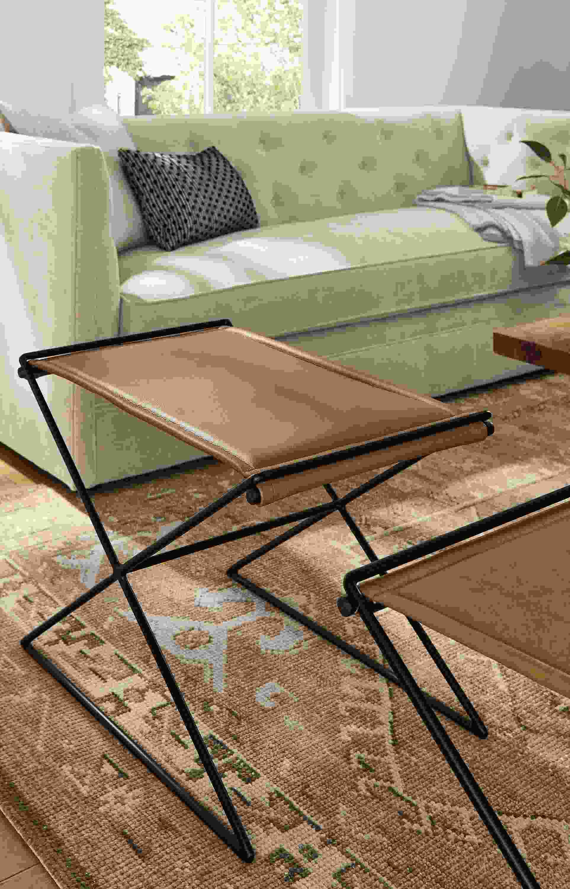 living room with two tavi stools in leather on darrah rug.