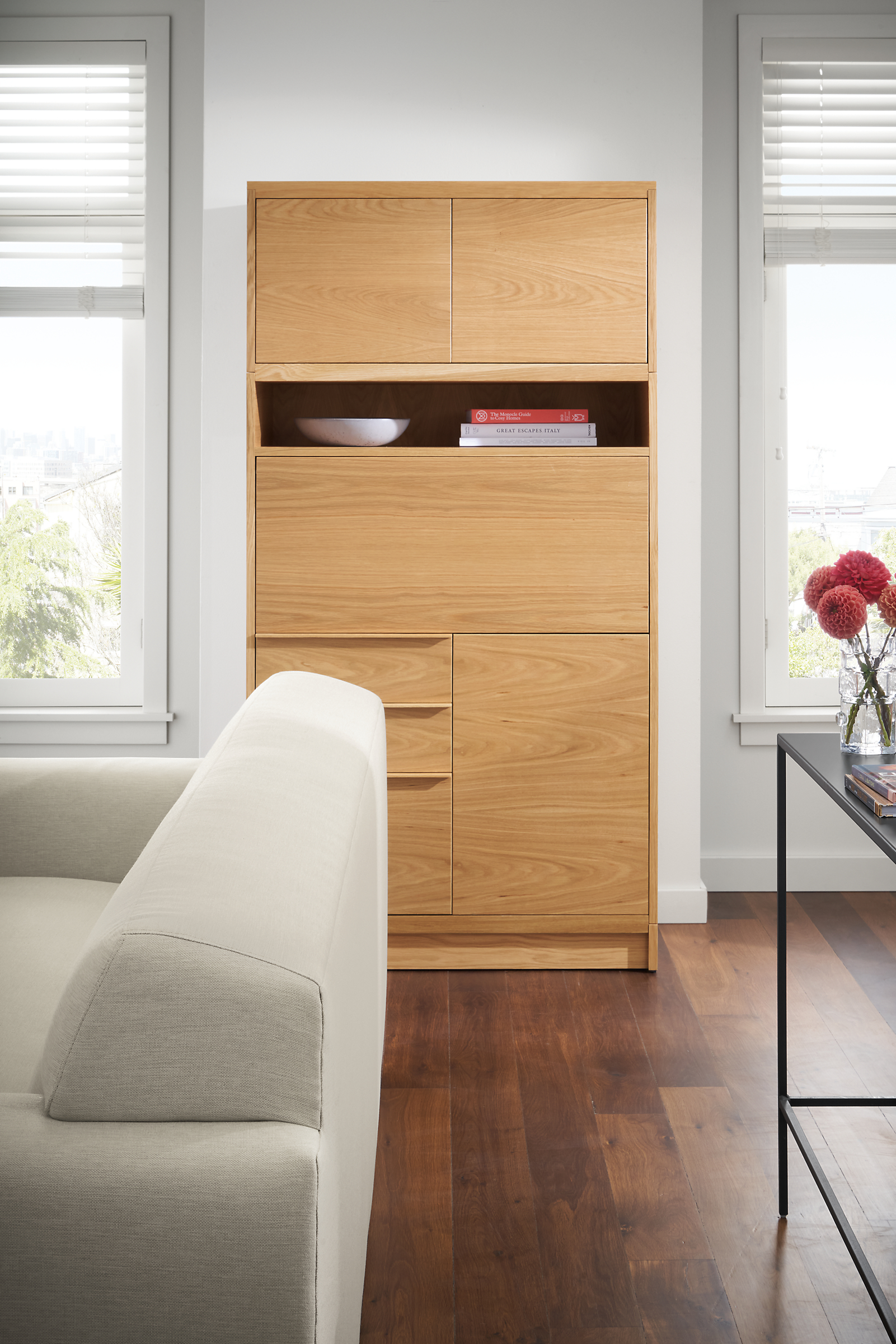 living room with taylor office armoire in white oak with wood base with drop-down desk folded up.