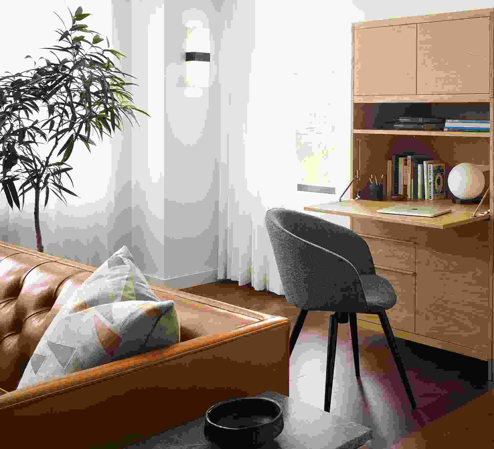 Detail of Taylor office wall unit in white oak with drop-down desk extended and Sylvan swivel side chair Radford Grey.