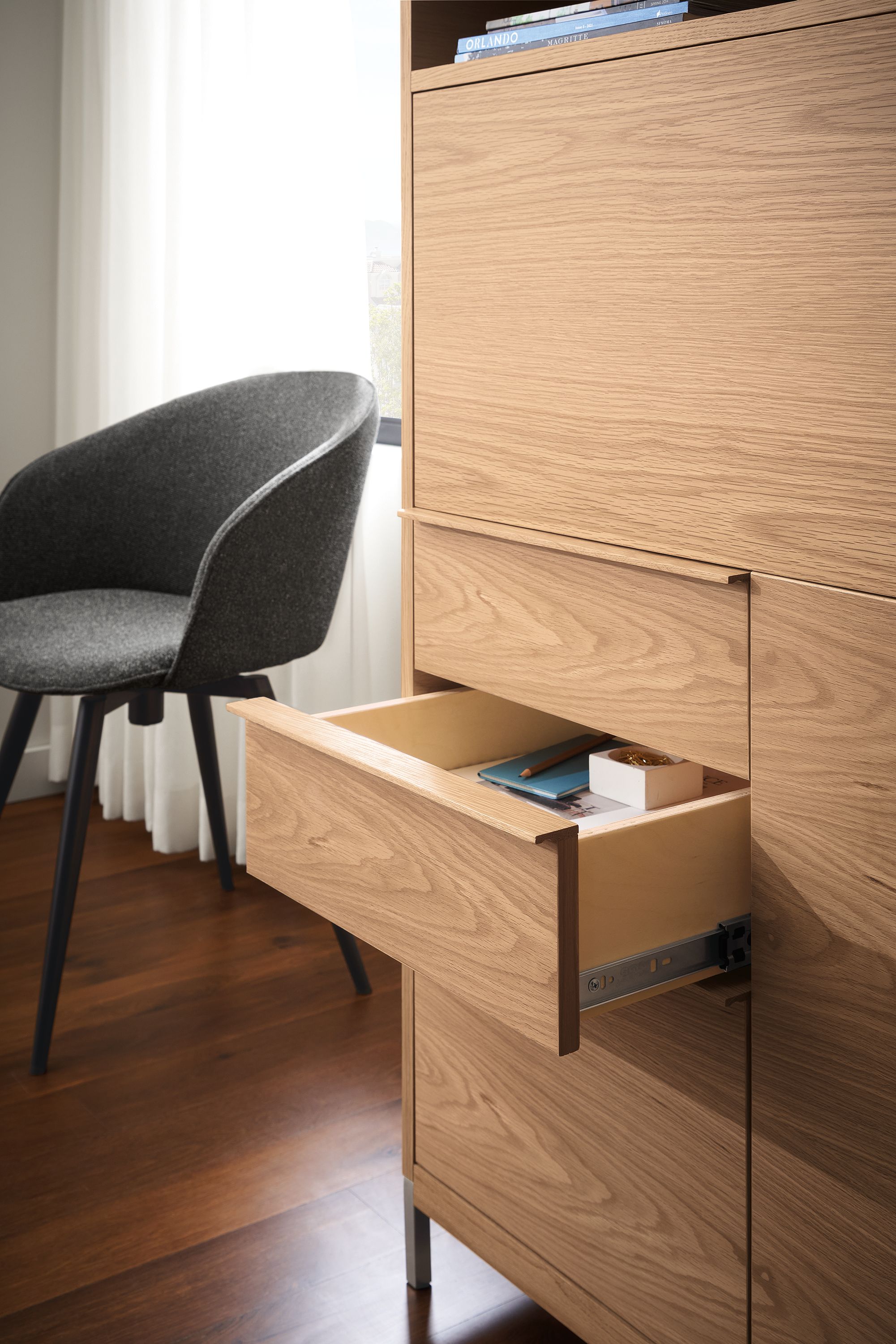 Detail of drawer of taylor office wall unit storage piece in rye on red oak shown with one drawer open.