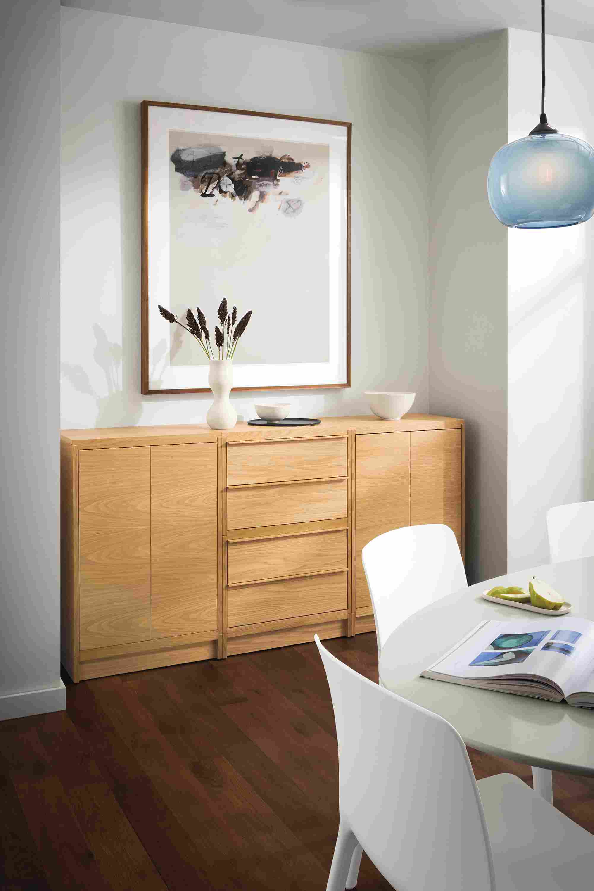 Dining room with Taylor storage cabinet in white oak with wood base, Julian table, Tiffany chairs and Gale pendant.