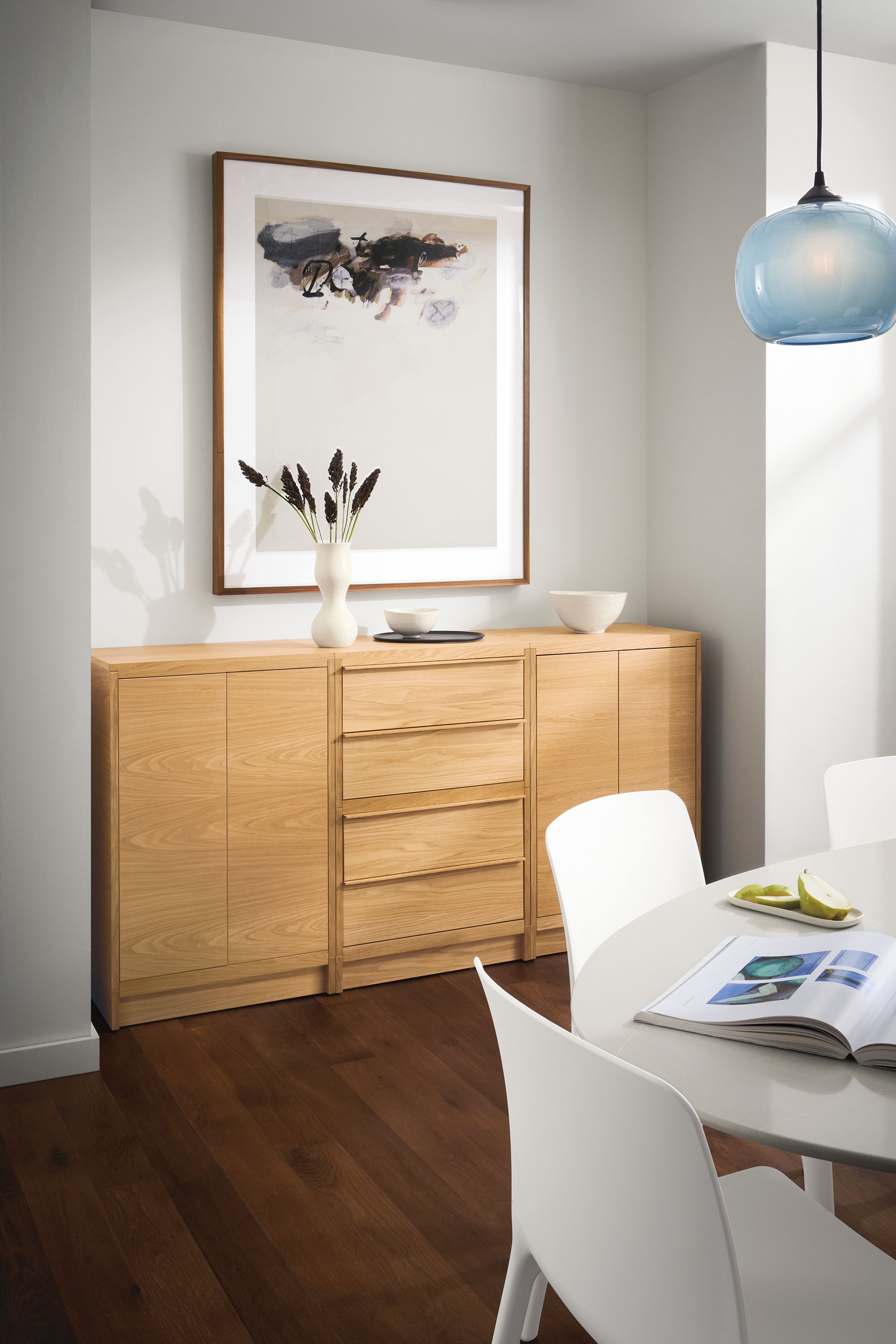 dining room with taylor storage cabinet in white oak with wood base, julian table, tiffany chairs, gale pendant.