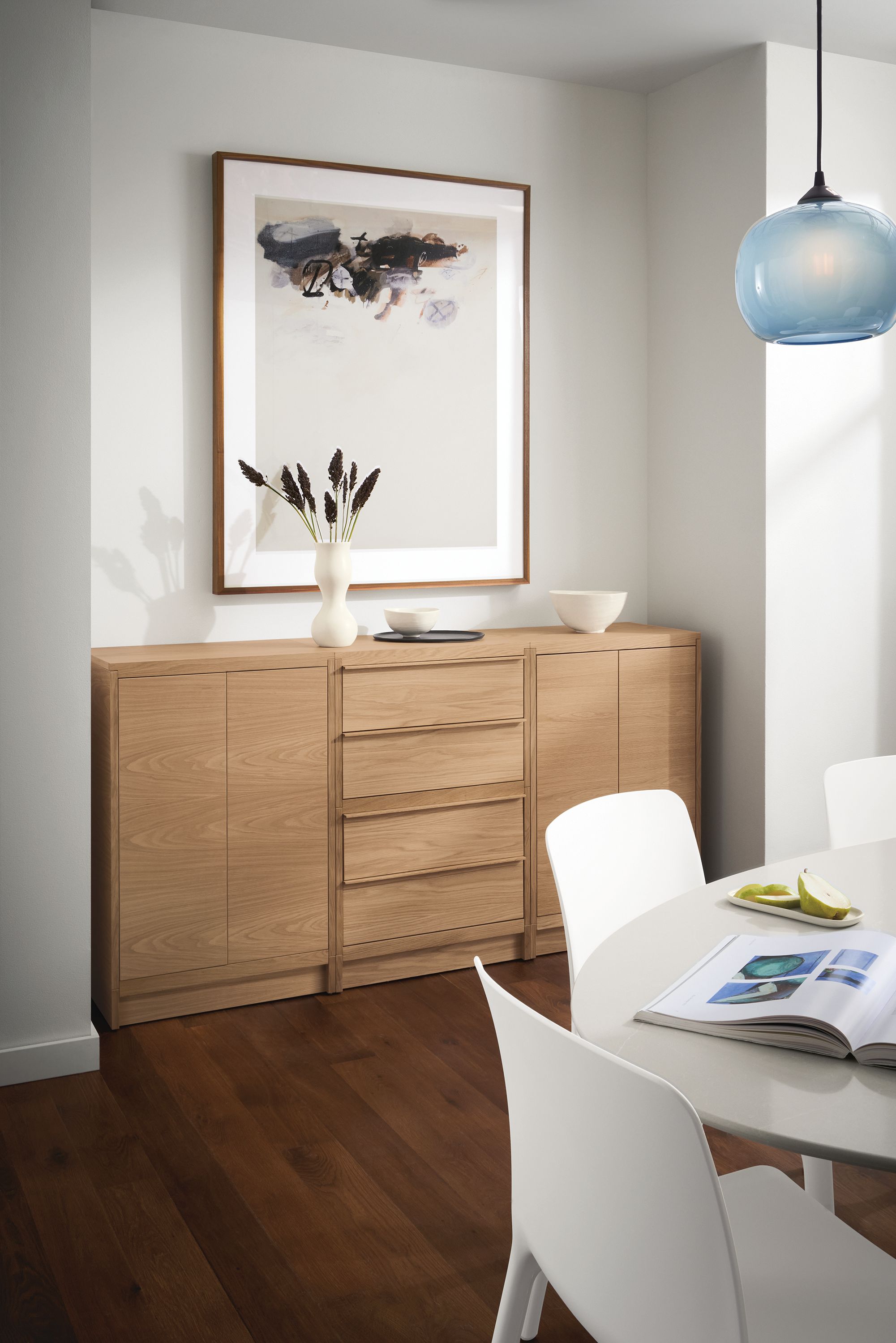 Dining room with Taylor storage cabinet in rye on red oak with wood base, Aria table, Tiffany chairs and Gale pendant.