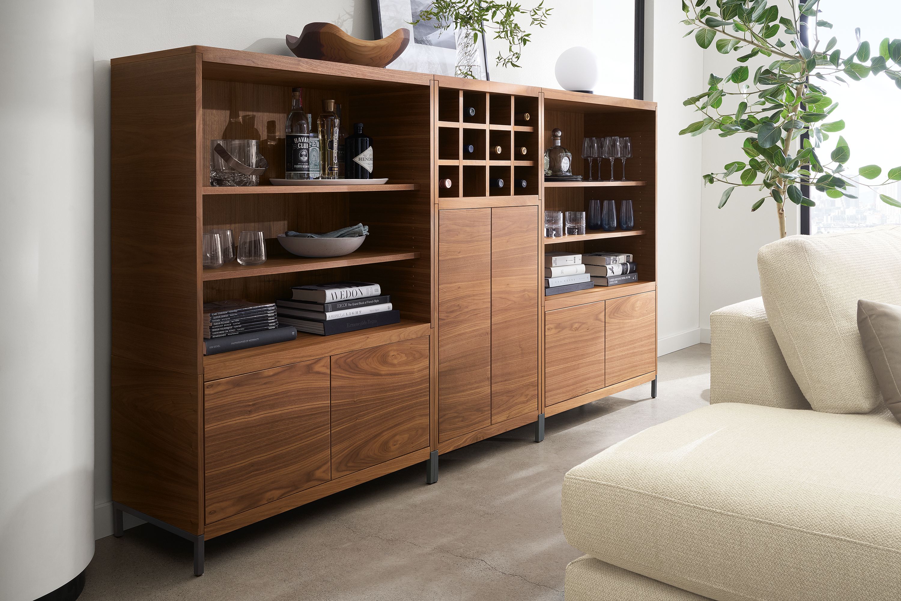 Living room with Taylor bookcase wall unit in walnut with graphite steel base.