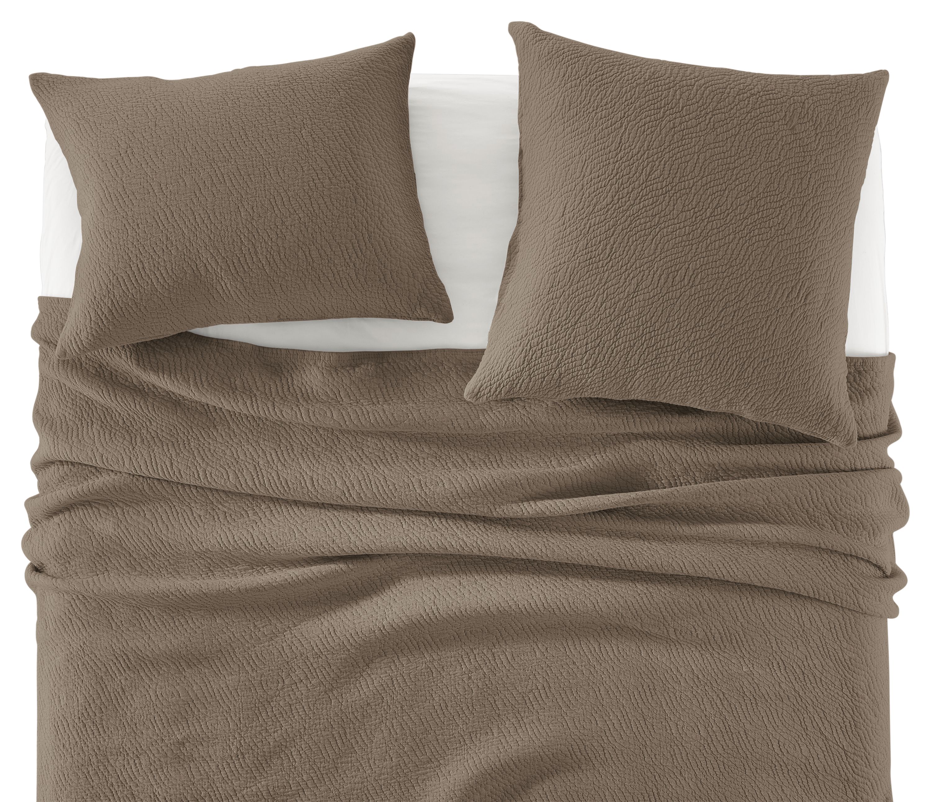 Detail of Thea Matelasse Full-Queen Coverlet and shams in Earth with White percale sheets.