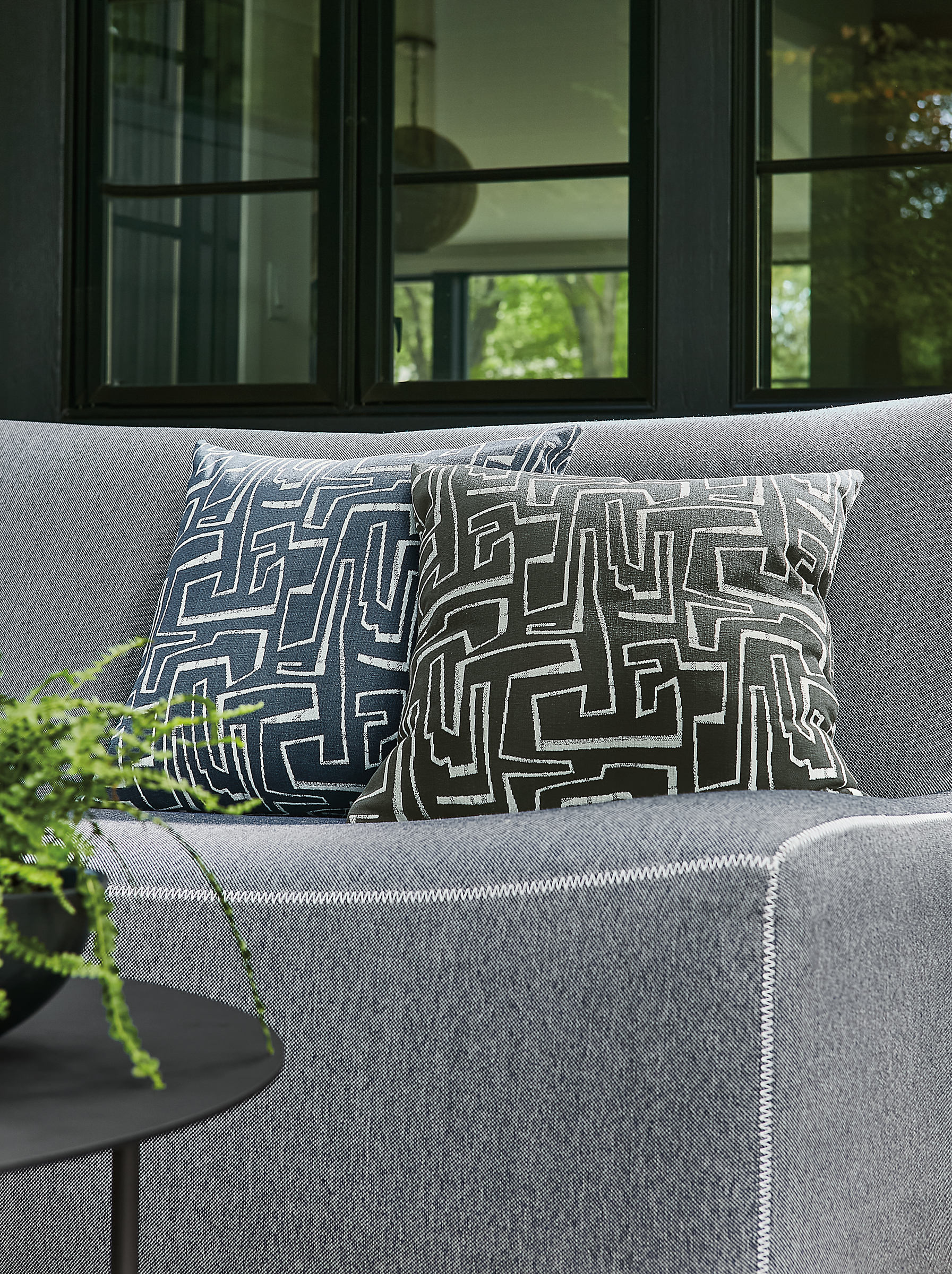 detail of two theon outdoor pillows on maya sofa in outdoor space.