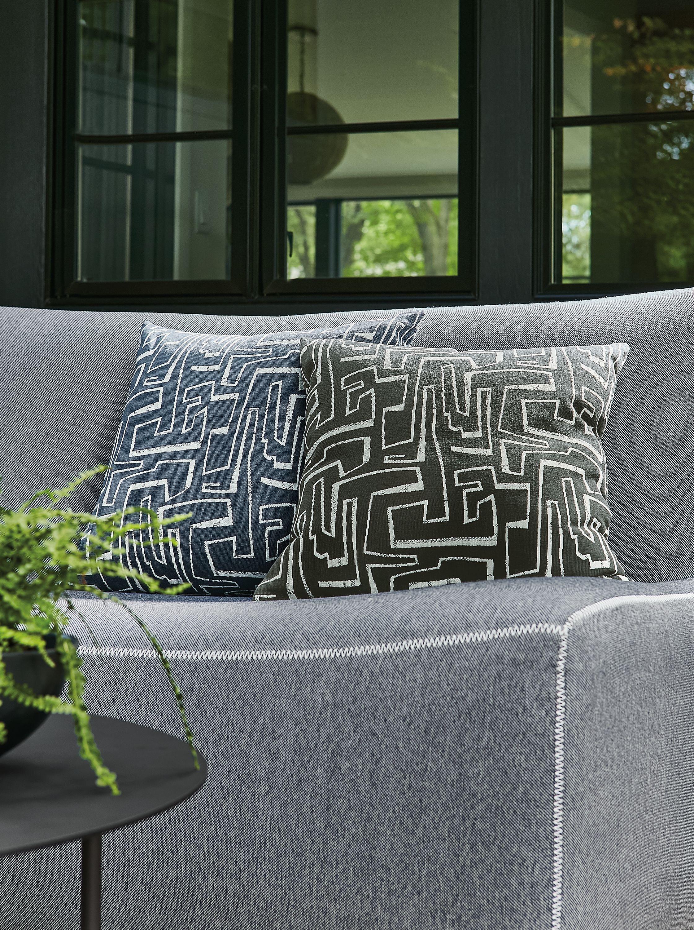 detail of two theon outdoor pillows on maya sofa in outdoor space.