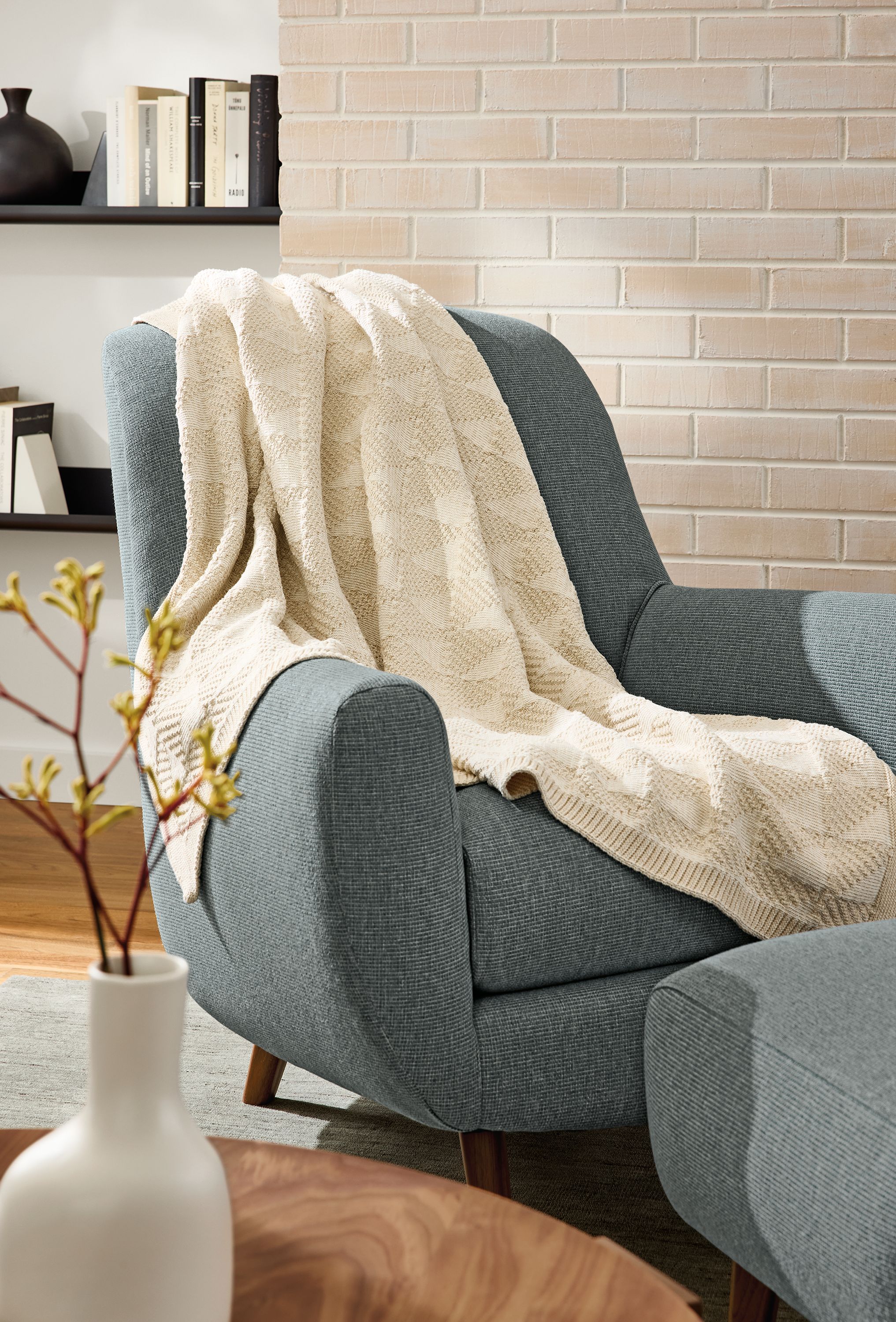Living area with Tifton Throw Blanket in Ivory draped over Leroy chair in Kesler slate.