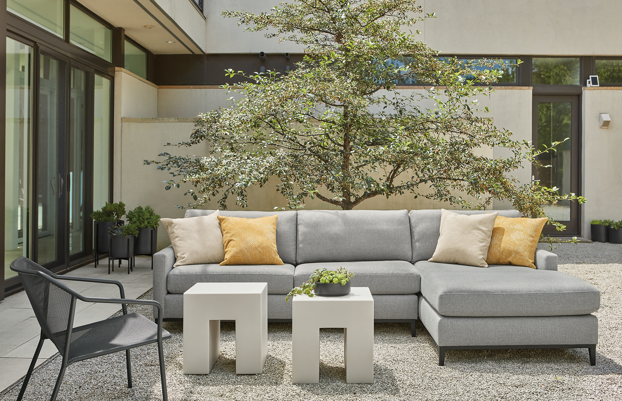 Tomas outdoor sofa with chaise in Mist steel fabric, two Vignelli cubes in light grey and Theo lounge chair in graphite.