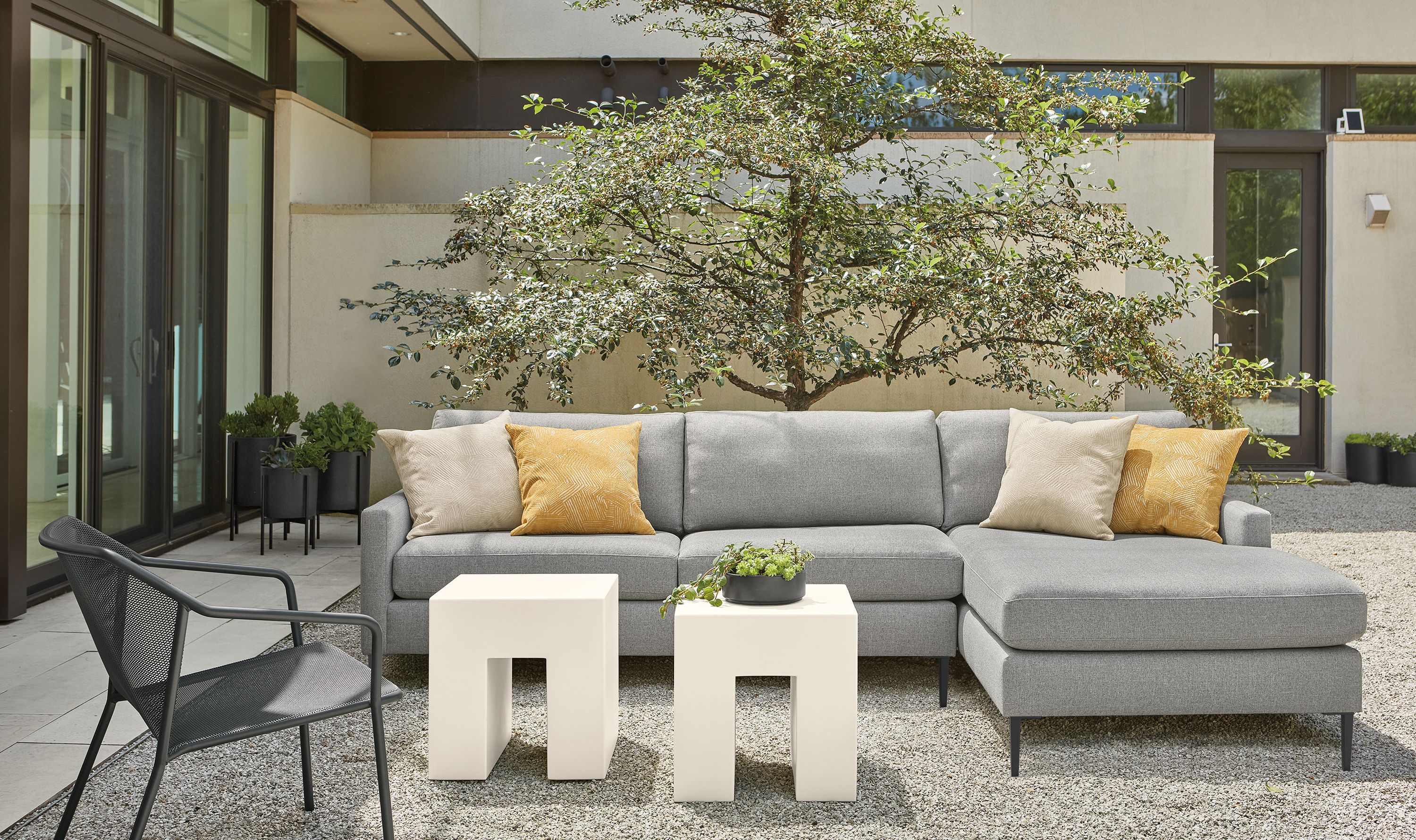 Tomas outdoor sofa with chaise in Mist steel fabric, two Vignelli cubes in light grey and Theo lounge chair in graphite.