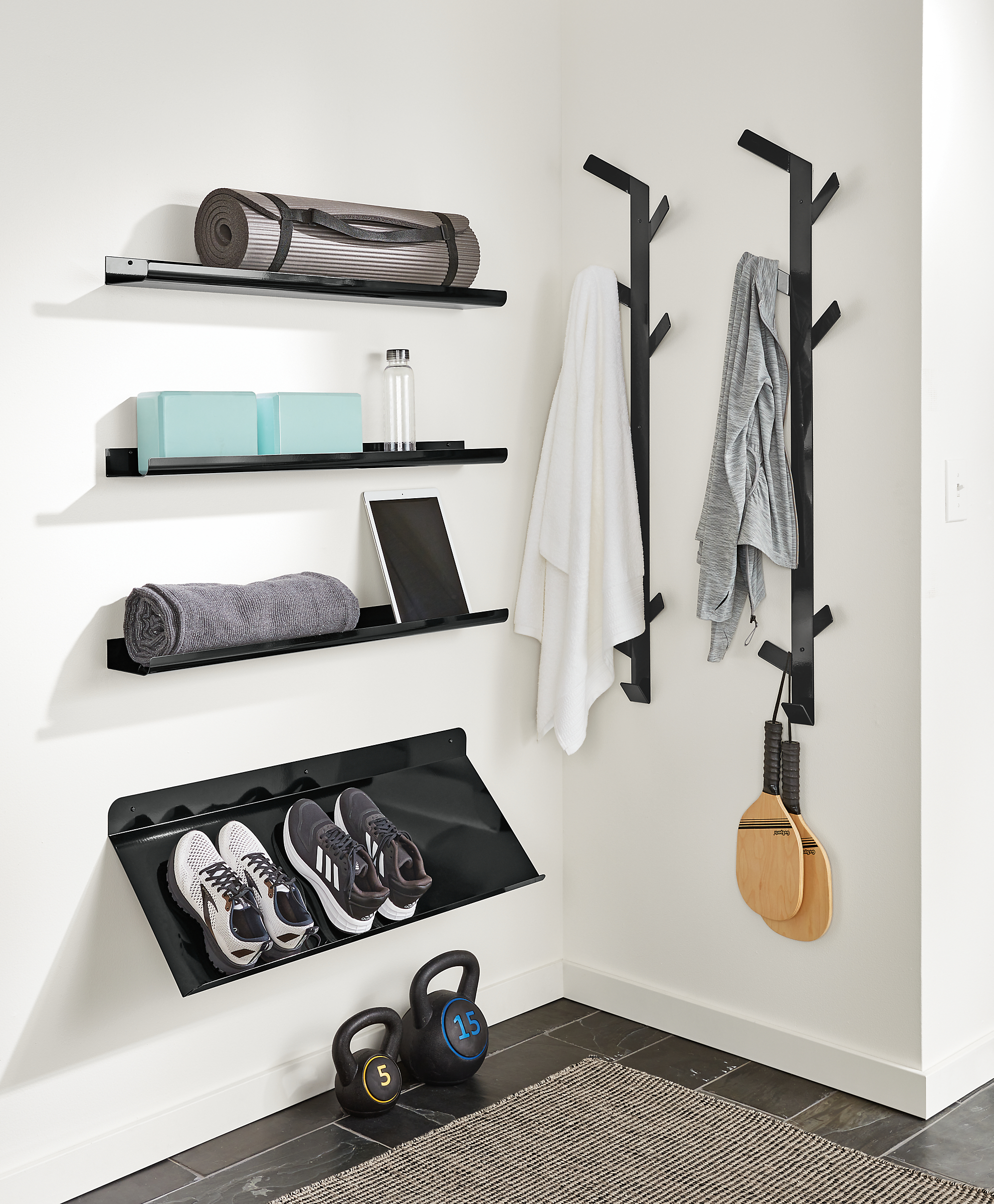 detail of trace picture ledges, esker shoe rack and crew vertical coat racks all mounted on wall in home gym