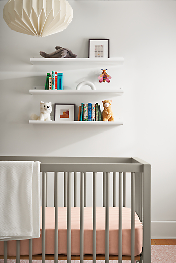 detail of aster crib in gray in kids room with shelves