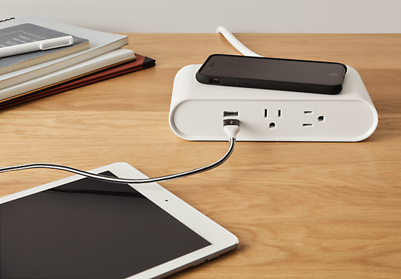 detail of Parsons table and trippel tabletop power charging outlet.