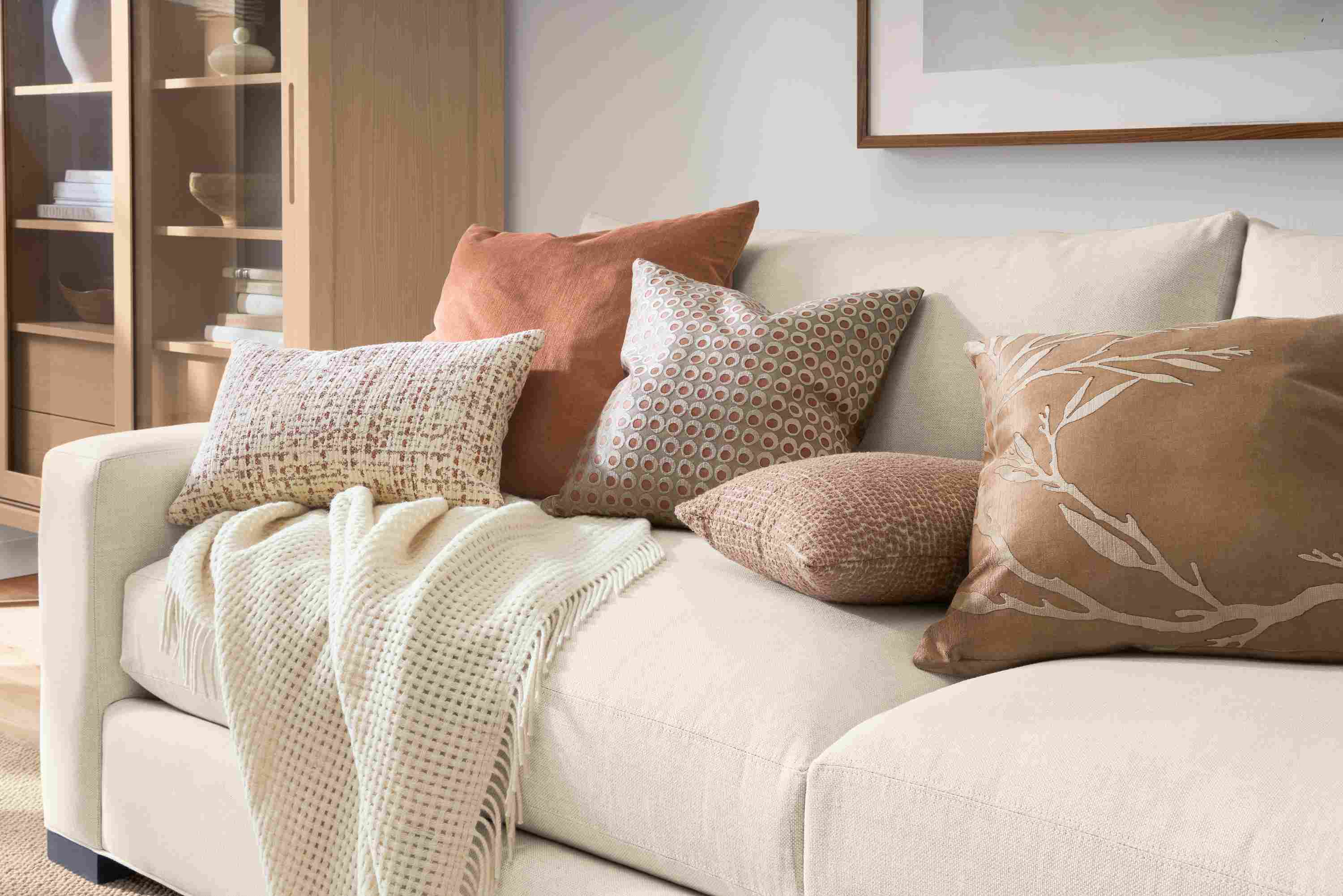 Group of pillows including Tromso, Windsor, Dot, Koko and Liana on a Metro sofa in Sumner Ivory.