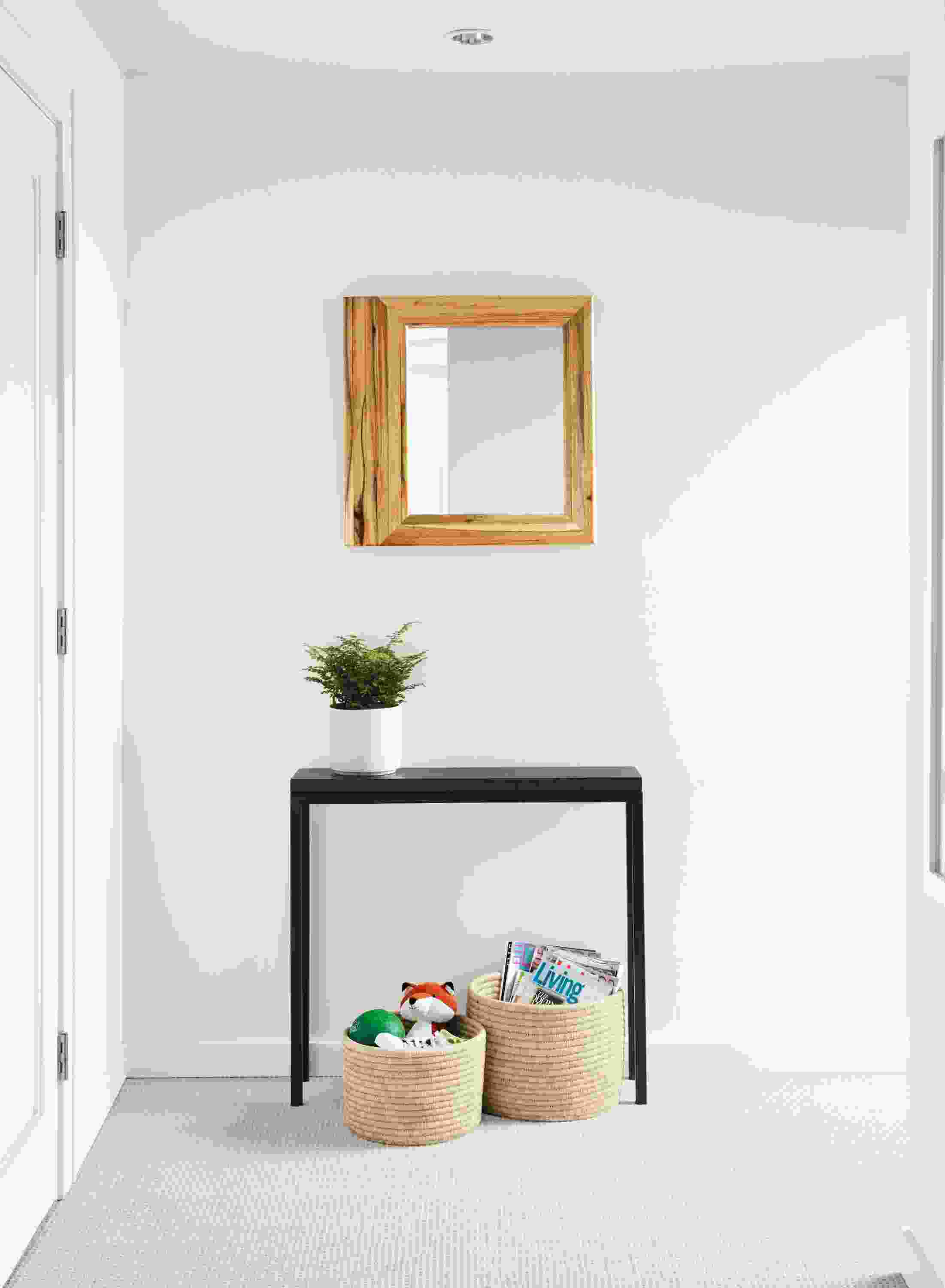 room setting including parsons table, trove mirror, shore planter, bangla storage baskets.