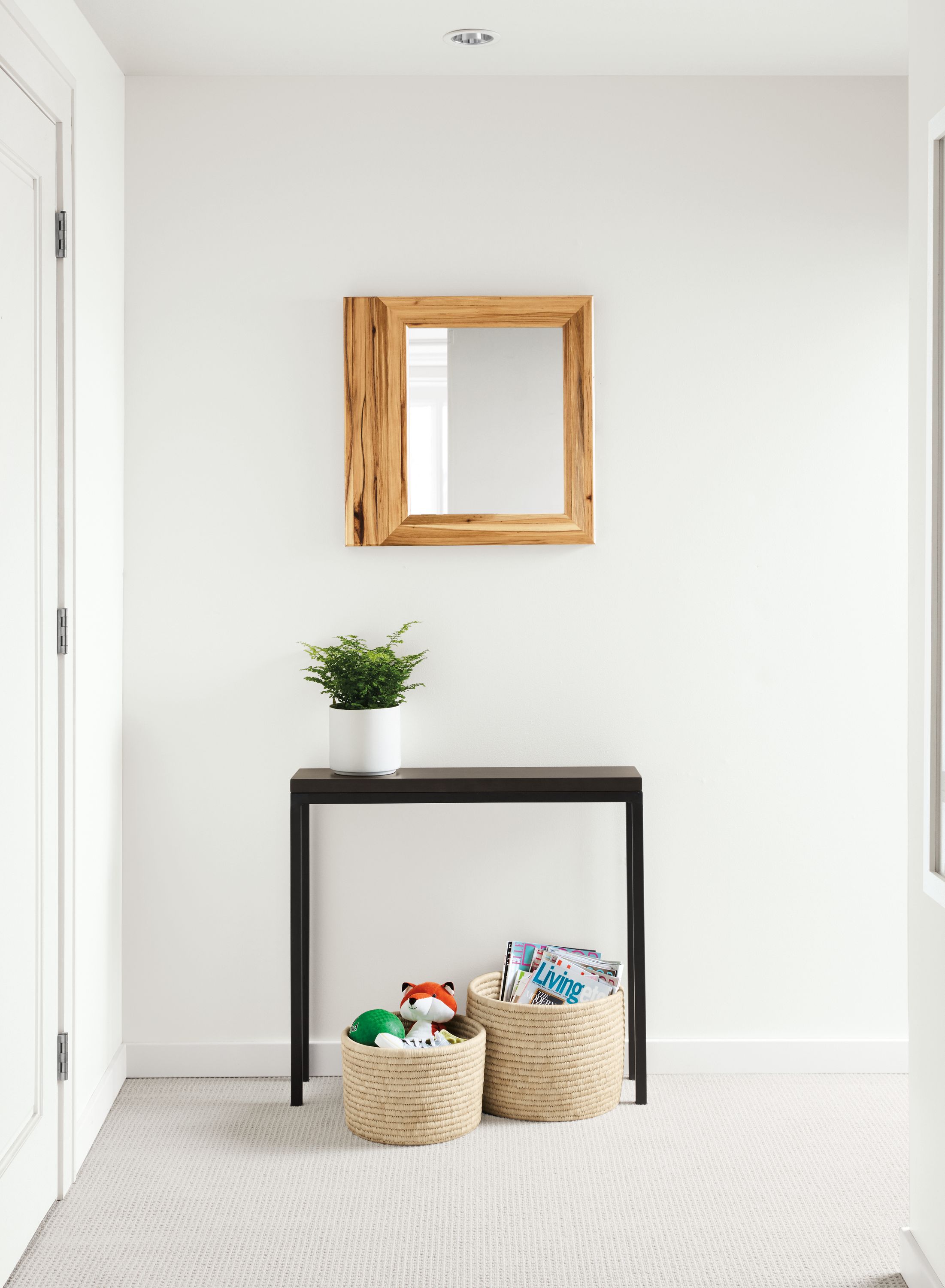 room setting including parsons table, trove mirror, shore planter, bangla storage baskets.