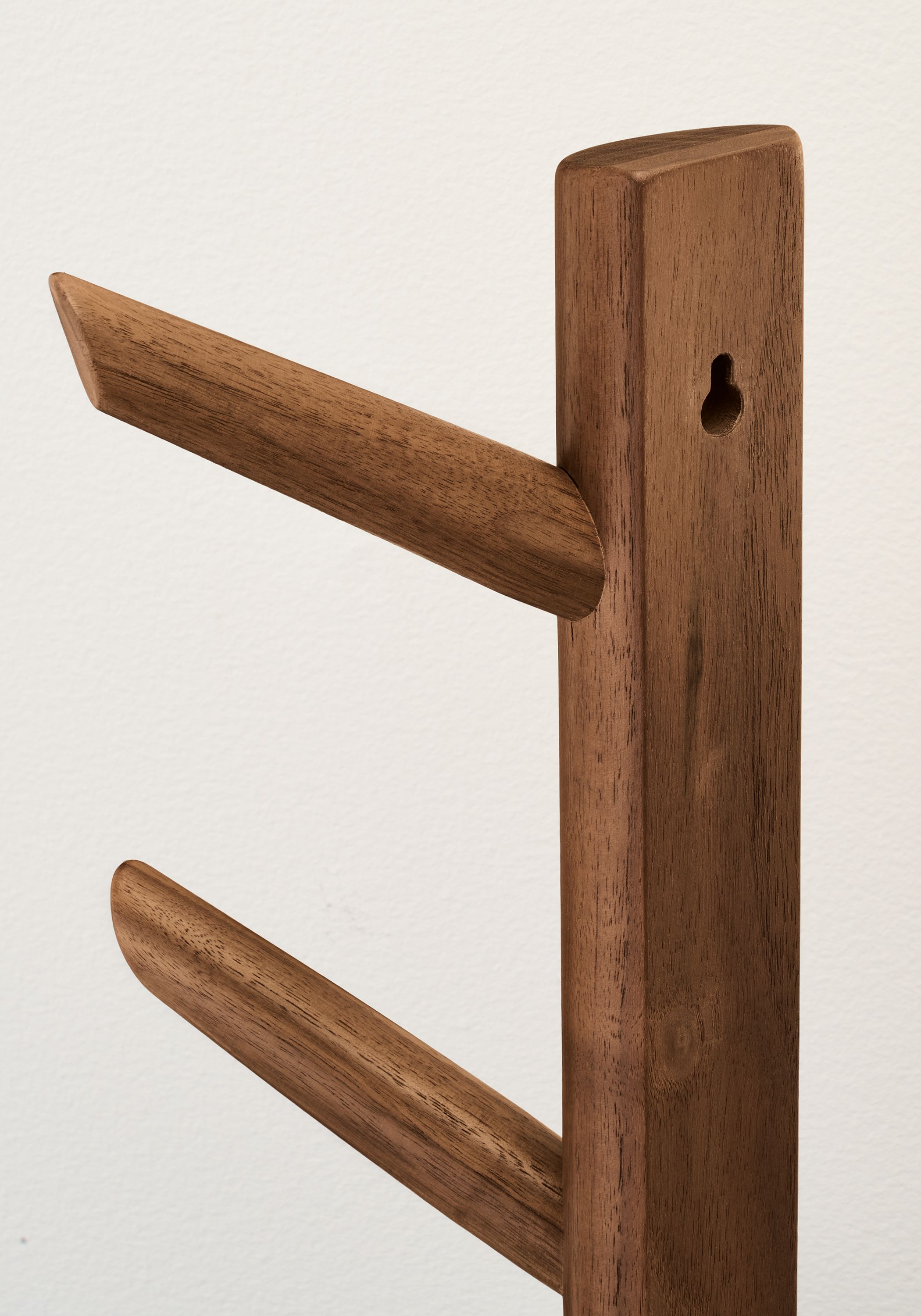 Detail of the back side of a Valet 24-inch high vertical wall hook in walnut showing the mounting hole.