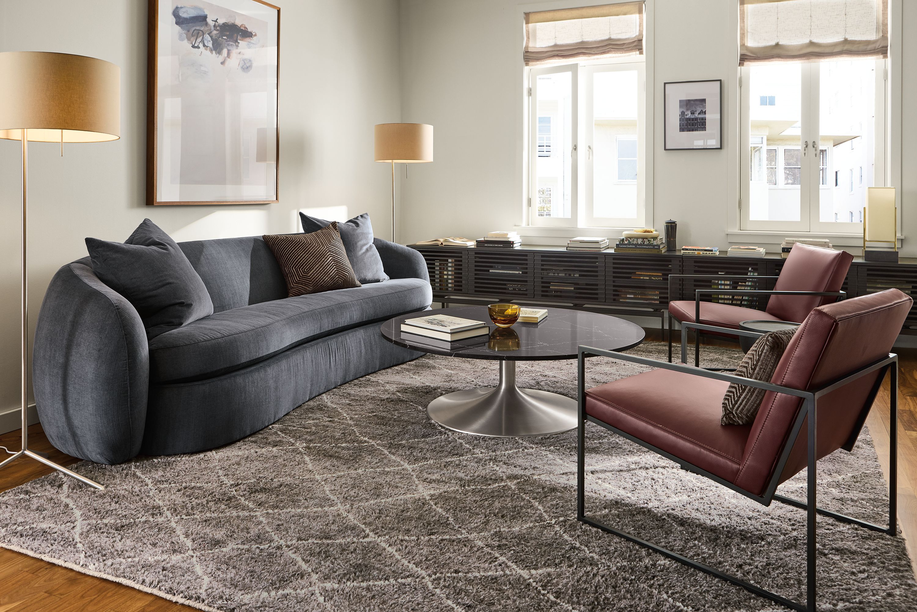Living room with Valora 106-wide benchseat sofa in windsor navy, 2 Novato chairs in pesaro merlot leather and kalindi rug in charcoal.