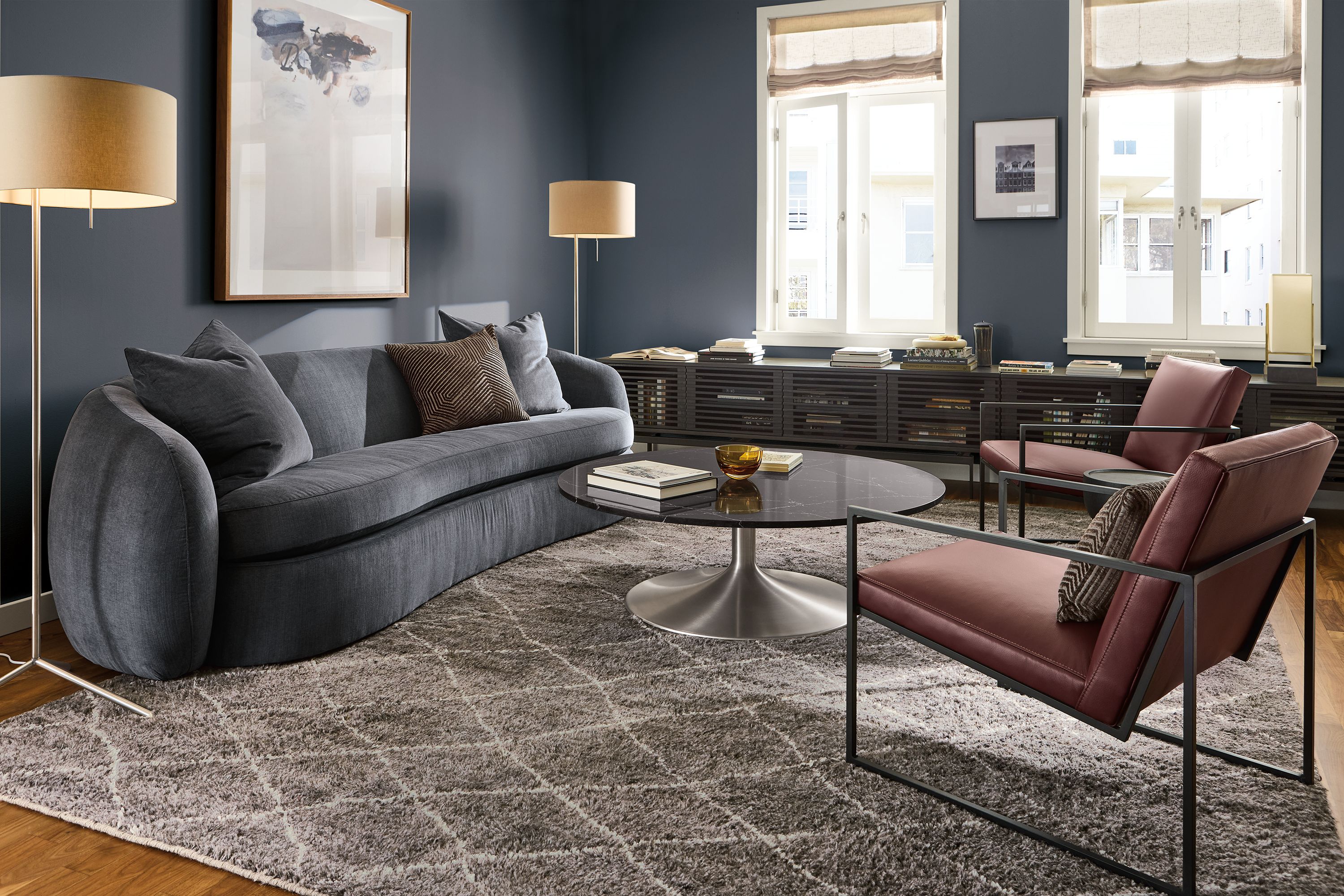 Living room with Valora 106-wide sofa in windsor navy, 2 Novato chairs in pesaro merlot leather and kalindi rug in charcoal.
