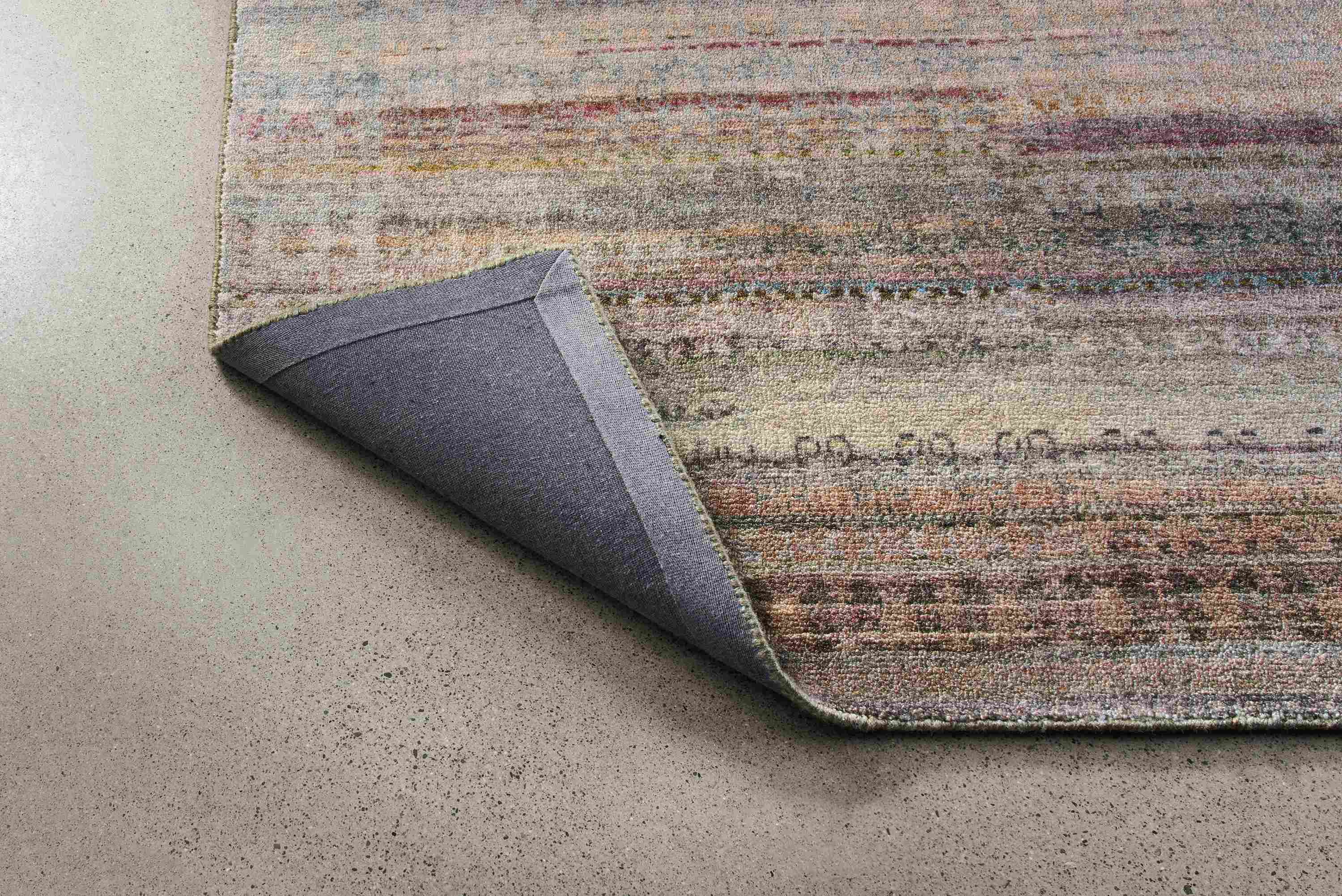 Varun 8 by 10 rug in multicolor shown with corner flipped up to show underside of rug.