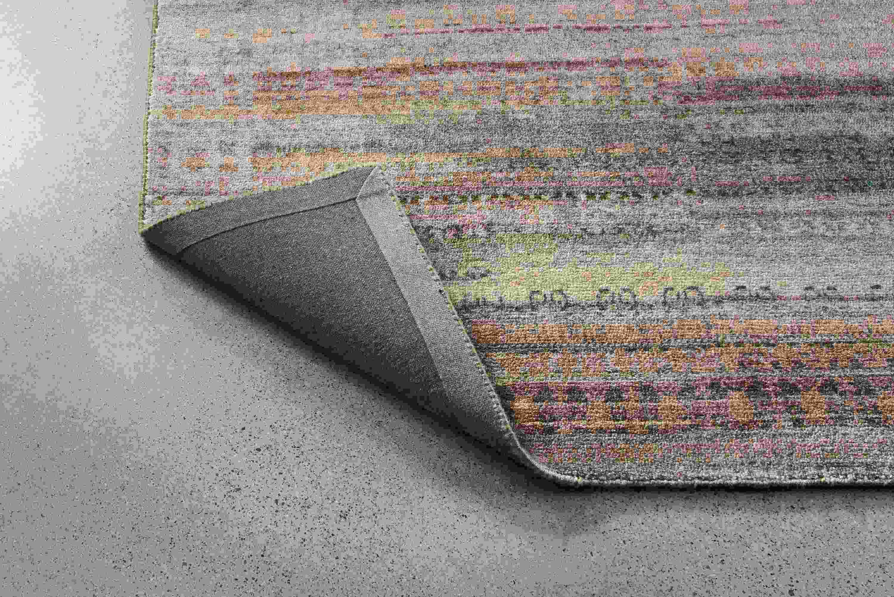 Varun 8 by 10 rug in multicolor shown with corner flipped up to show underside of rug.