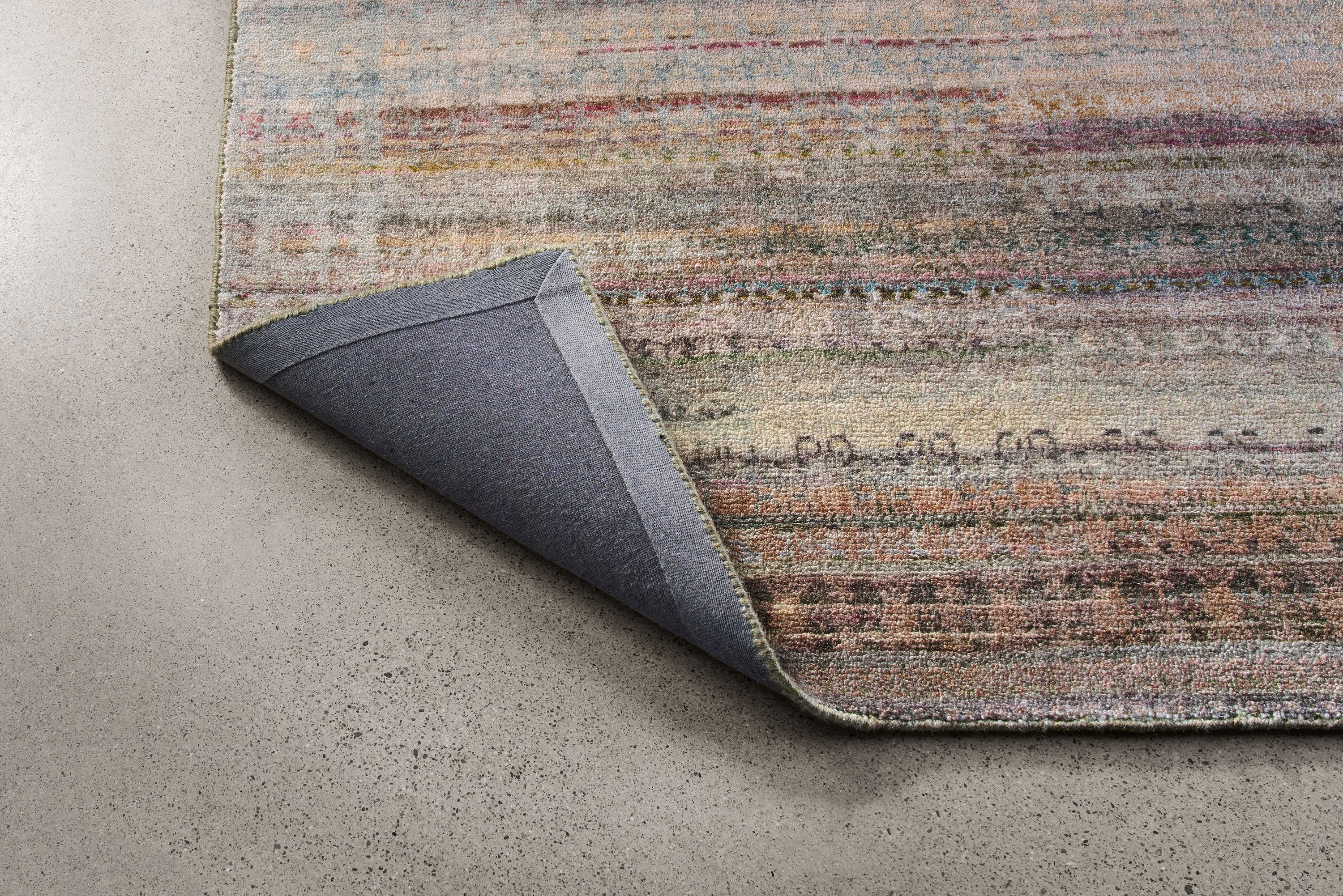 Varun 8 by 10 rug in multicolor shown with corner flipped up to show underside of rug.