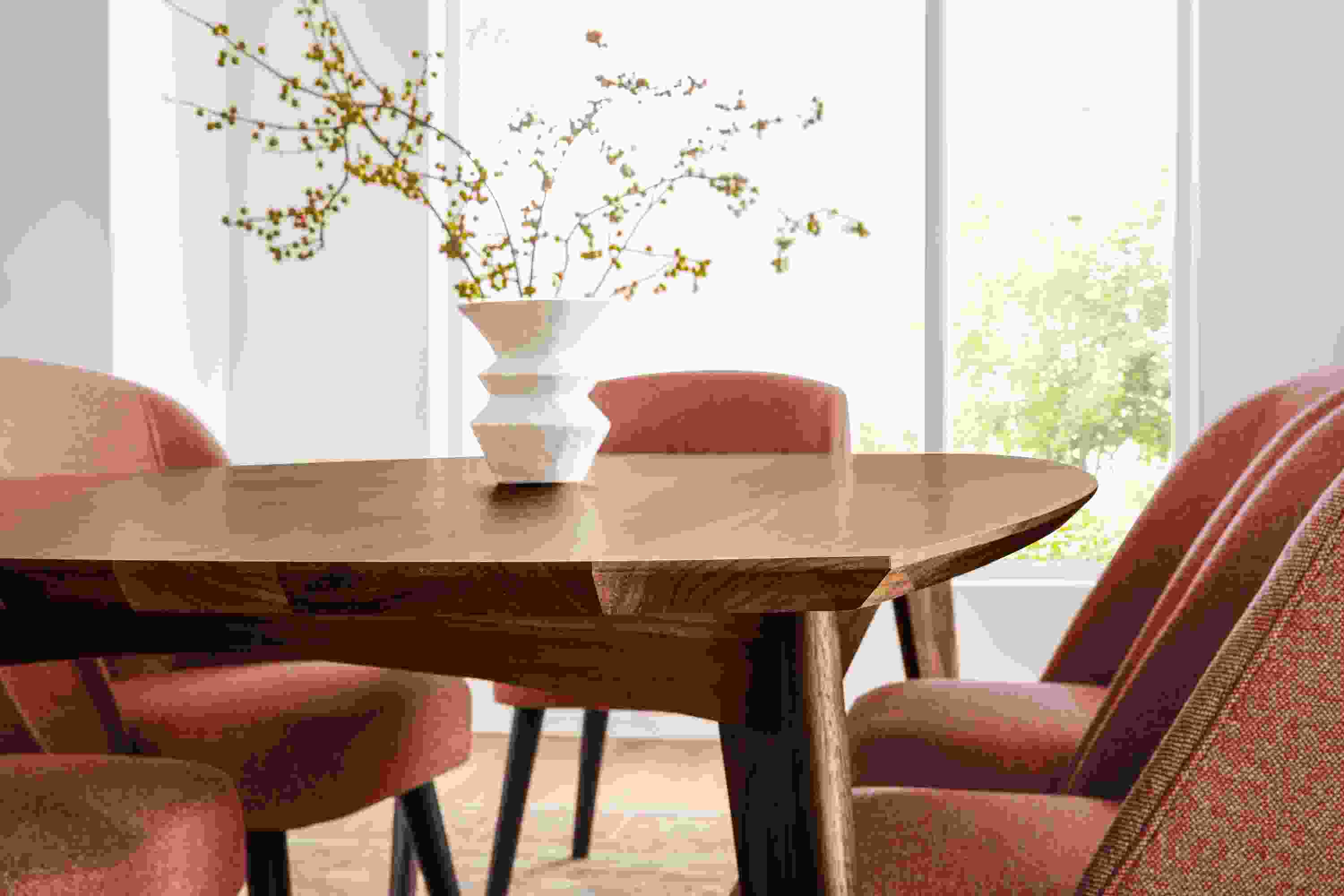 Detail of Ventura dining table in walnut and Cora side chairs in Tatum Spice fabric.