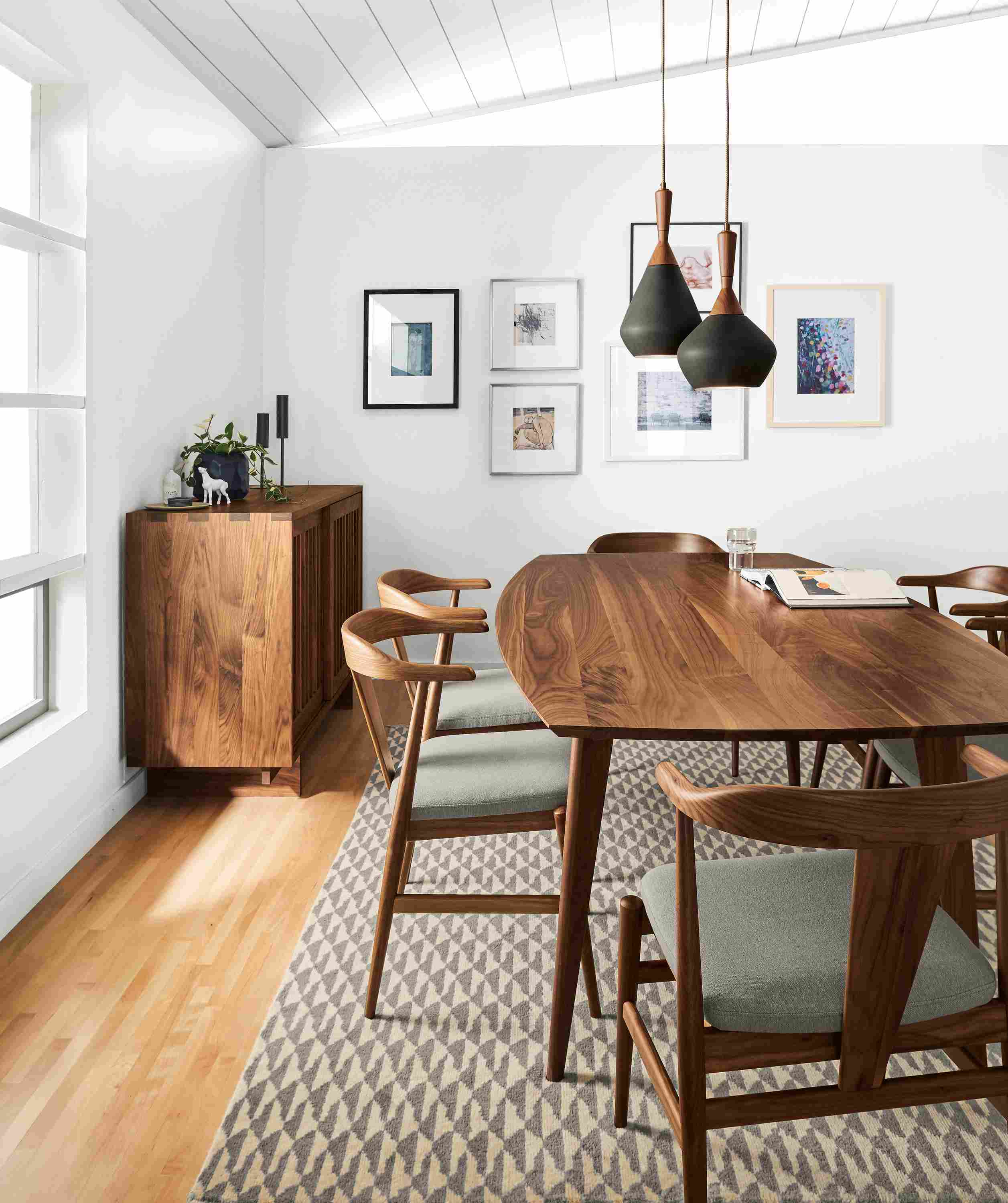 Dining room with Ventura dining table in walnut and Evan arm chairs in walnut with Flint Cement cushions.